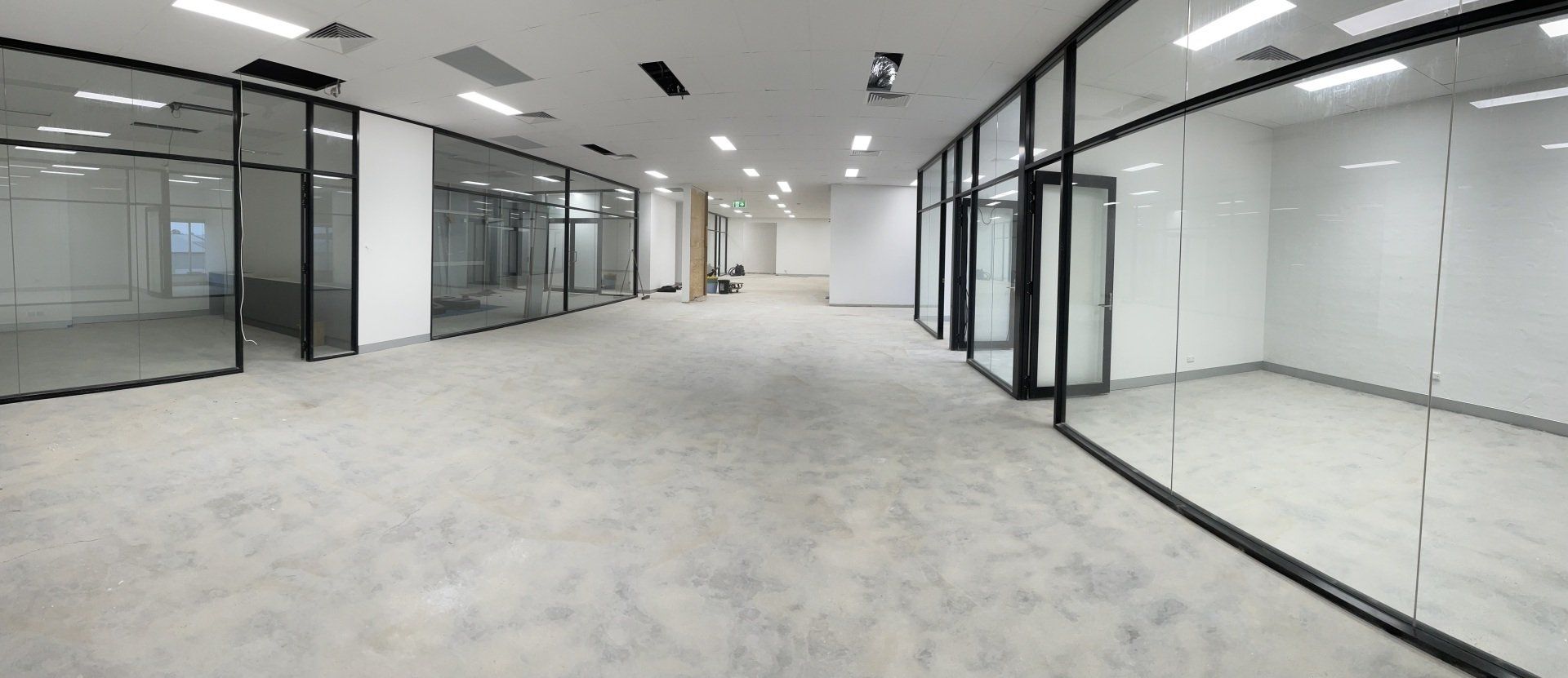 A Large Empty Room with A Lot of Glass Walls and Doors — Completely Plastered North Coast in Goonellabah, NSW