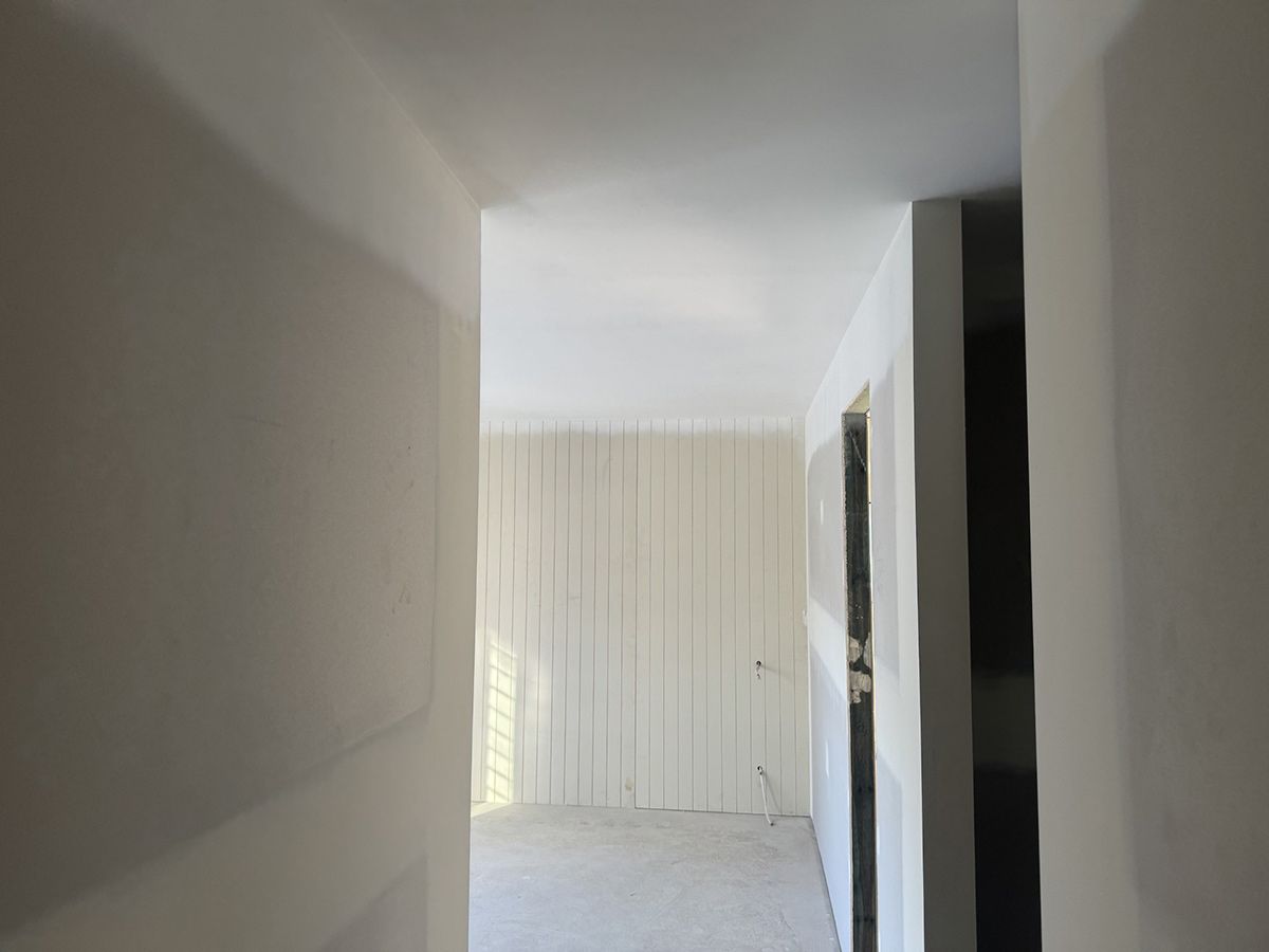 A Hallway in A House with White Walls and A Window — Completely Plastered North Coast in Goonellabah, NSW