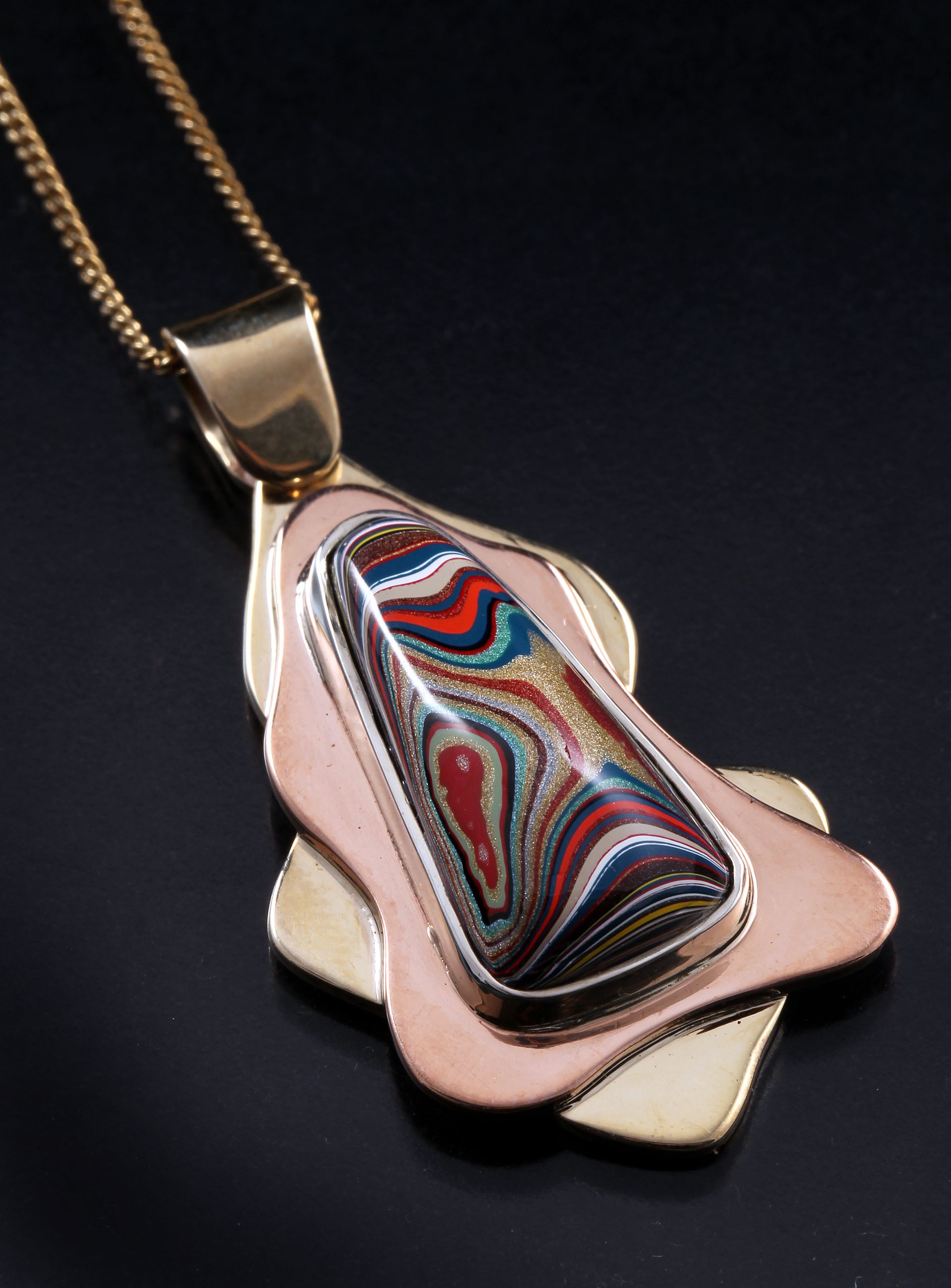 A necklace with a key shaped pendant on a gold chain.