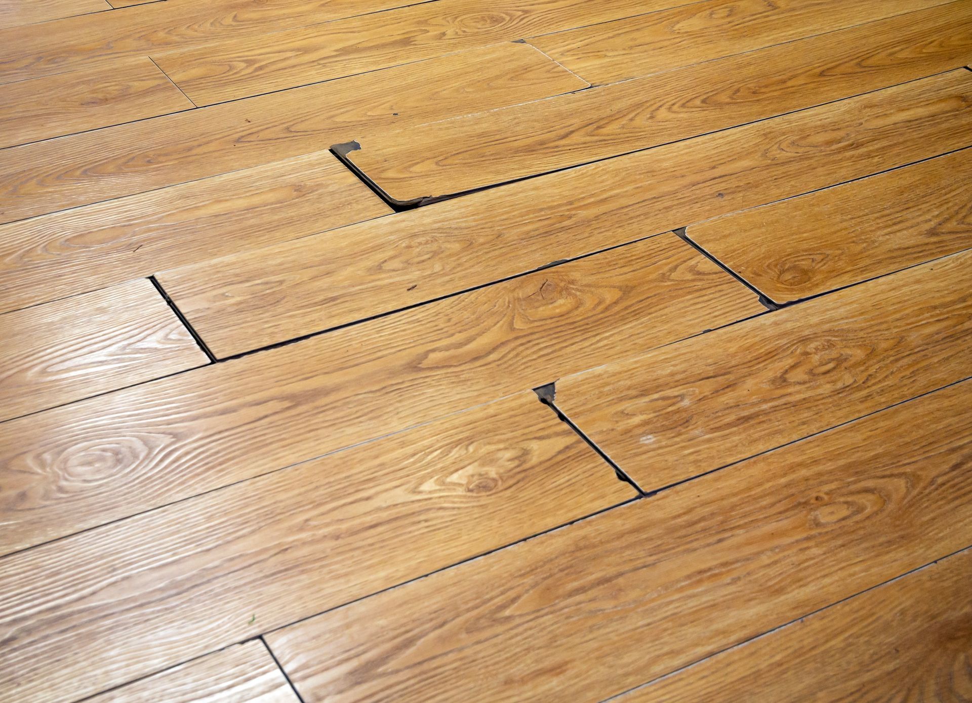 Wooden floorboards with gaps and a missing section.
