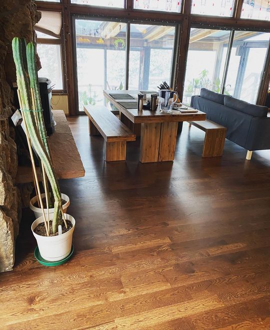Worker man staining wood floors