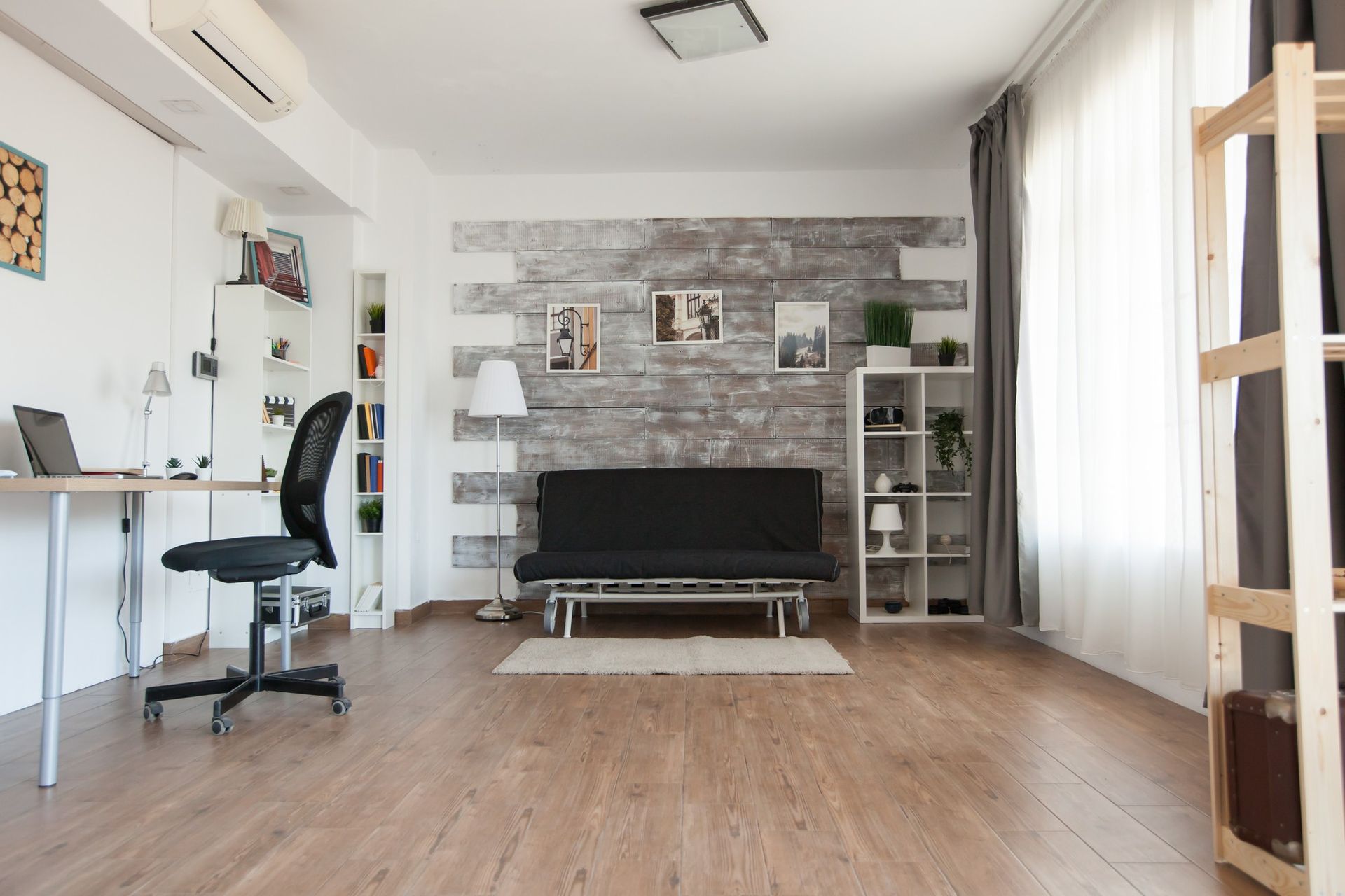 A living room with a couch , desk and chair.