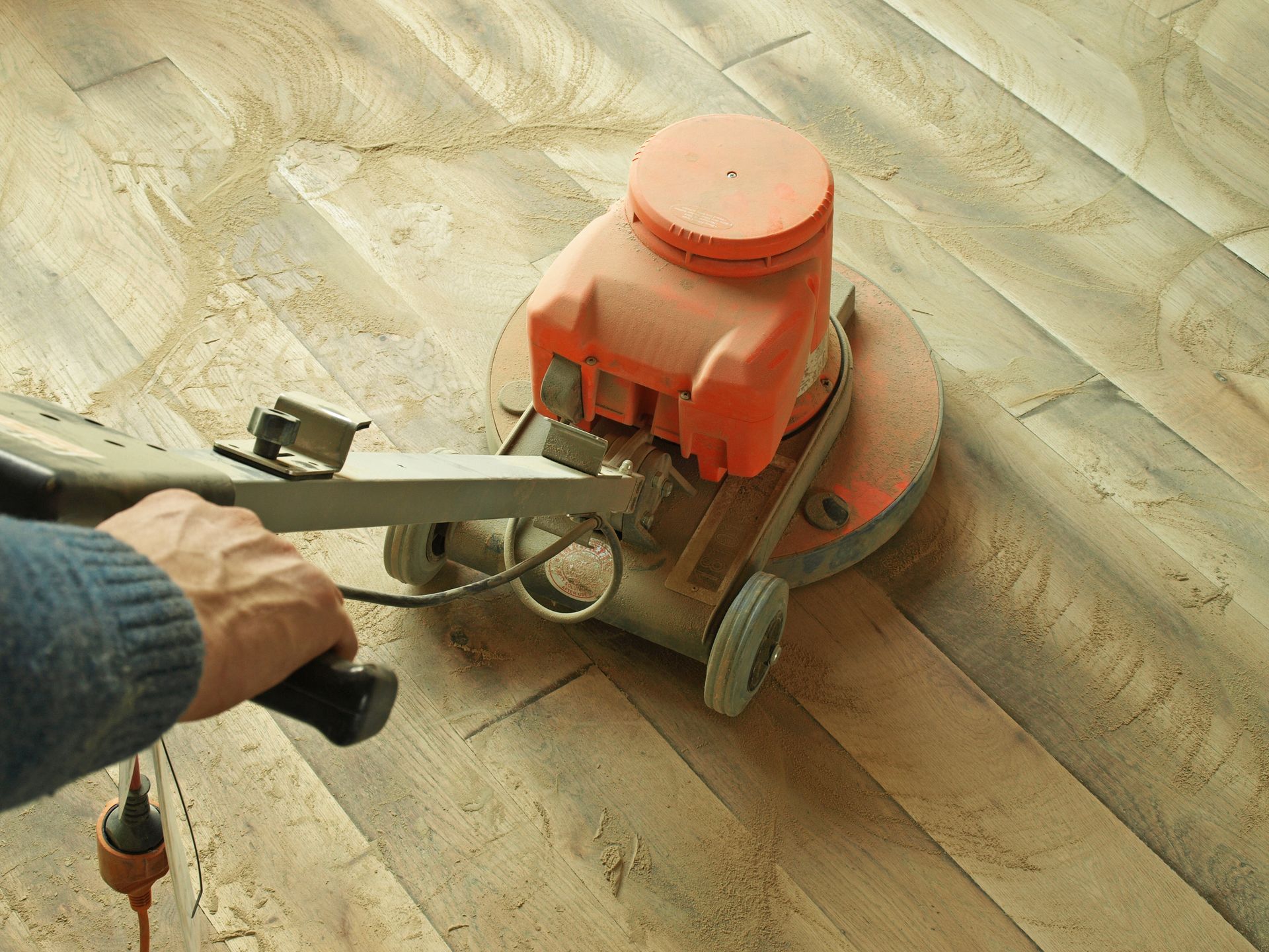 A person is using a machine to polish a wooden floor.