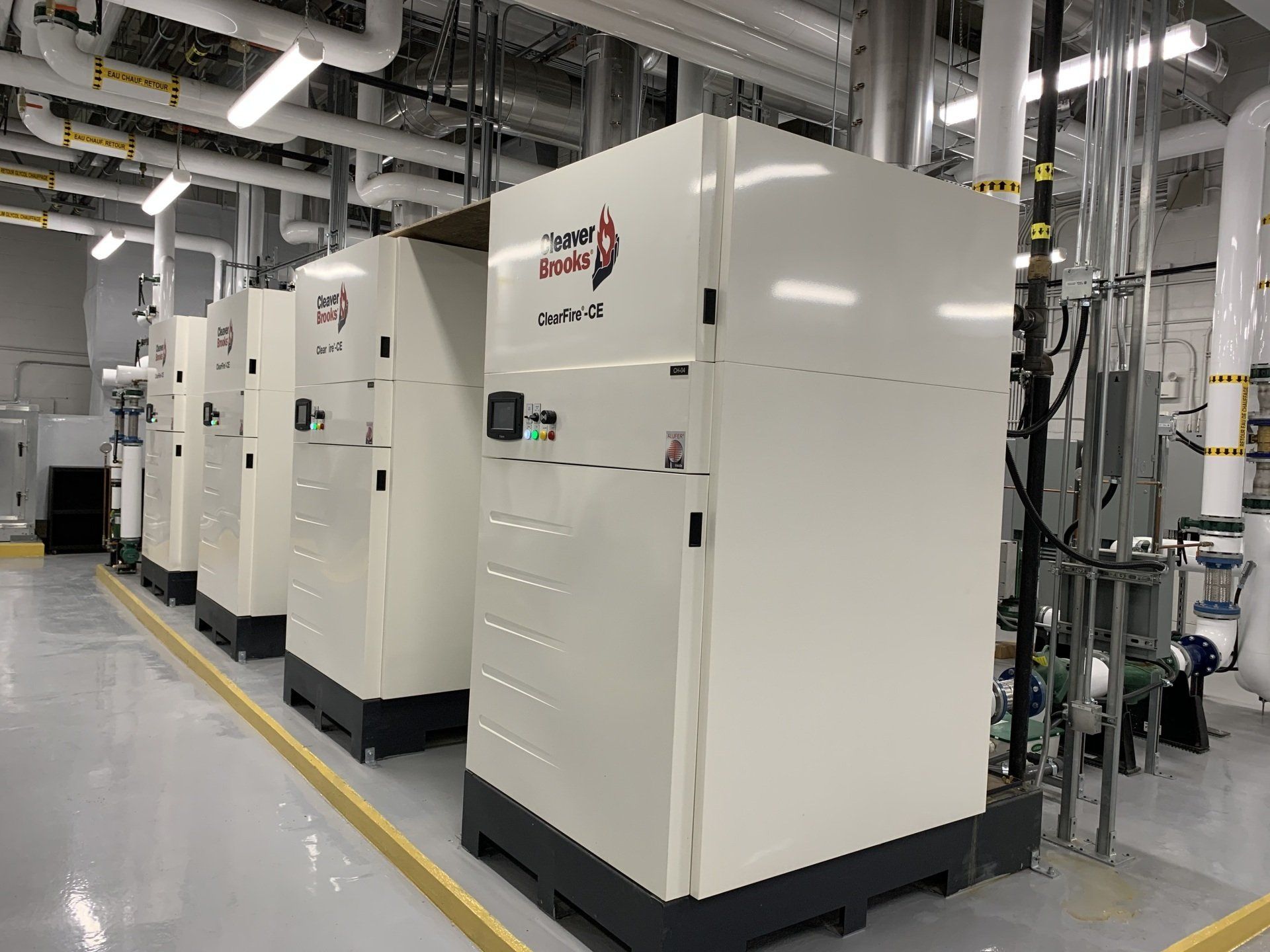 Une rangée de boîtes blanches sont alignées dans une pièce.