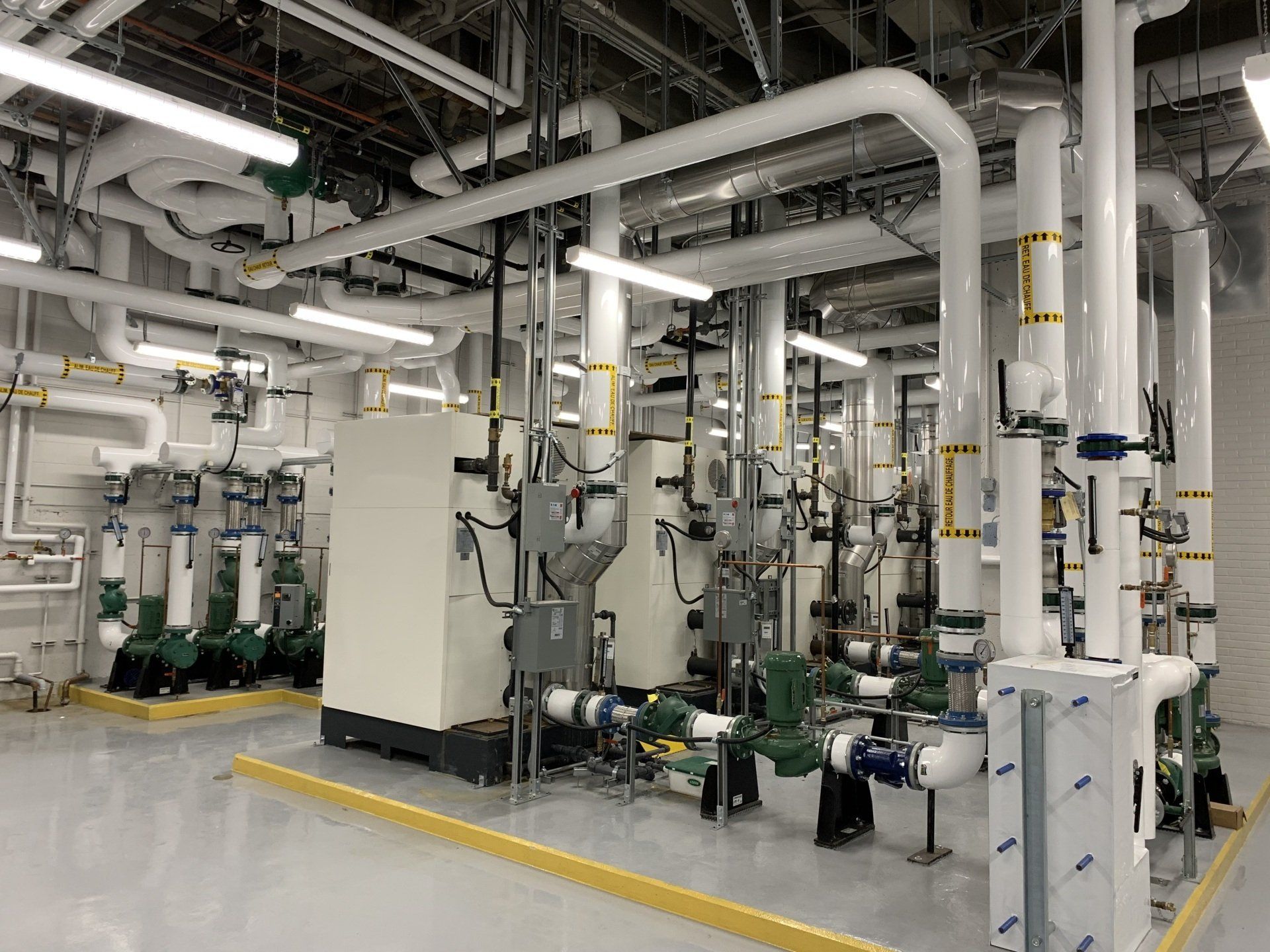 Une grande pièce remplie de nombreux tuyaux et machines.