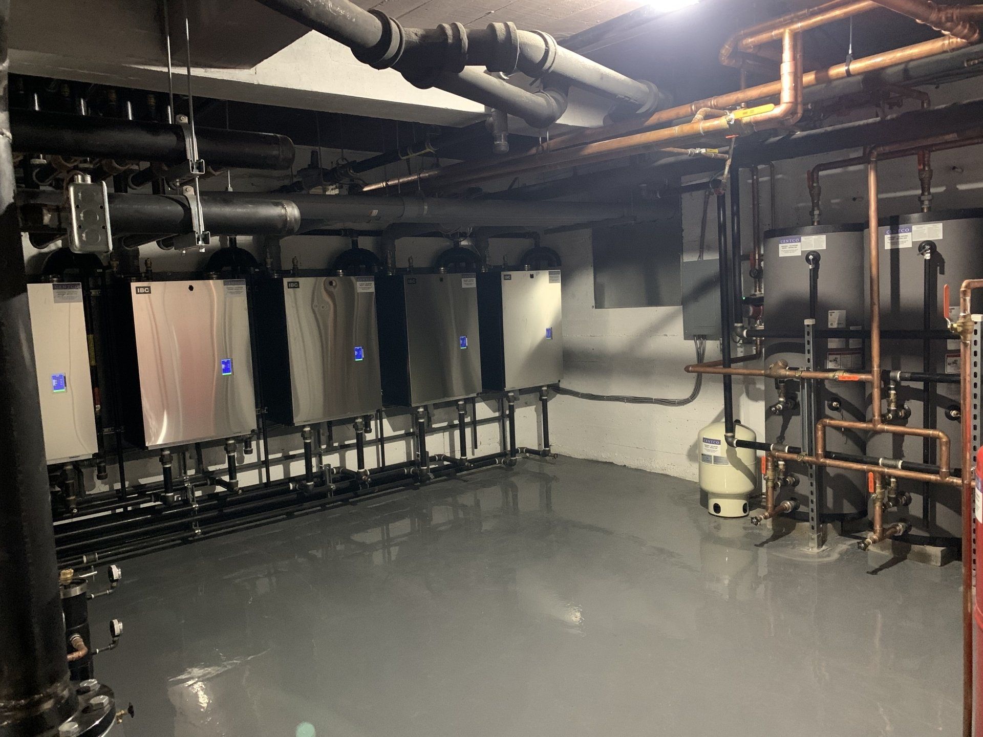 Une pièce avec beaucoup de tuyaux et de radiateurs.