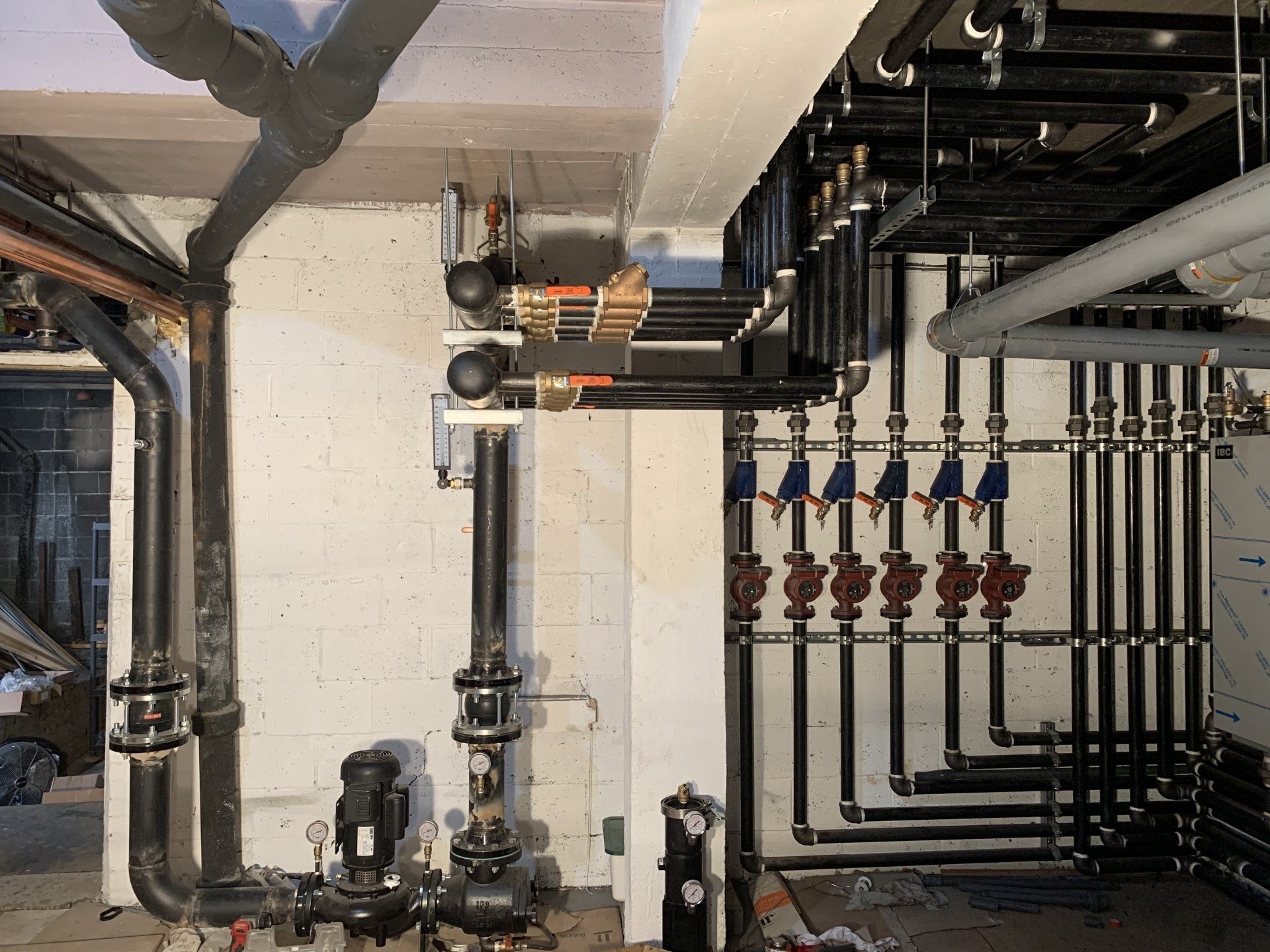 Une pièce avec beaucoup de tuyaux suspendus au plafond