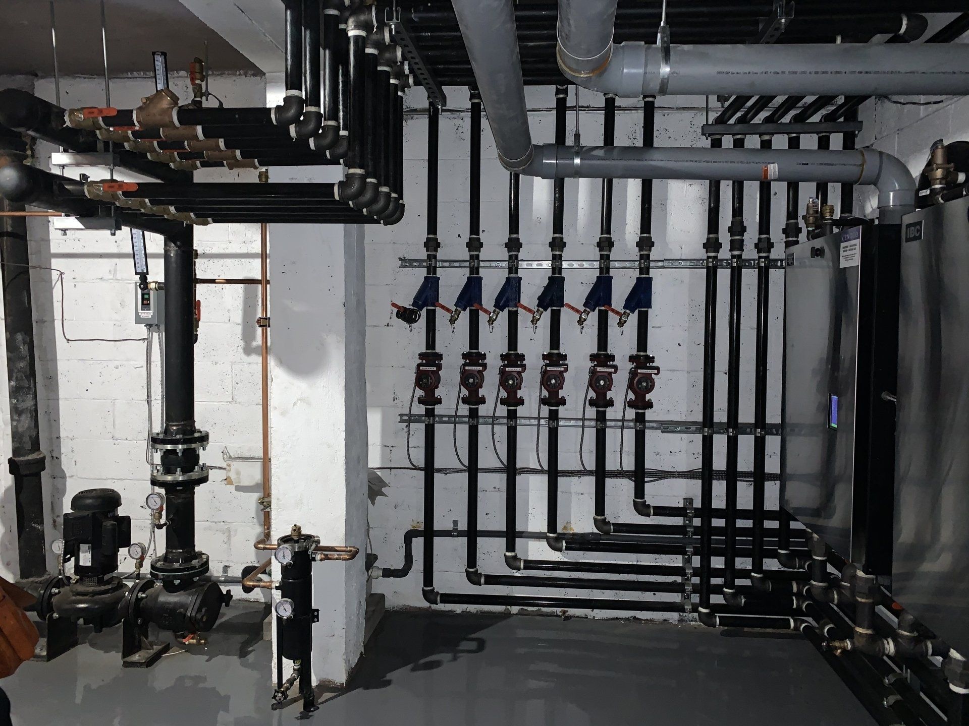 Une pièce remplie de nombreux tuyaux et vannes