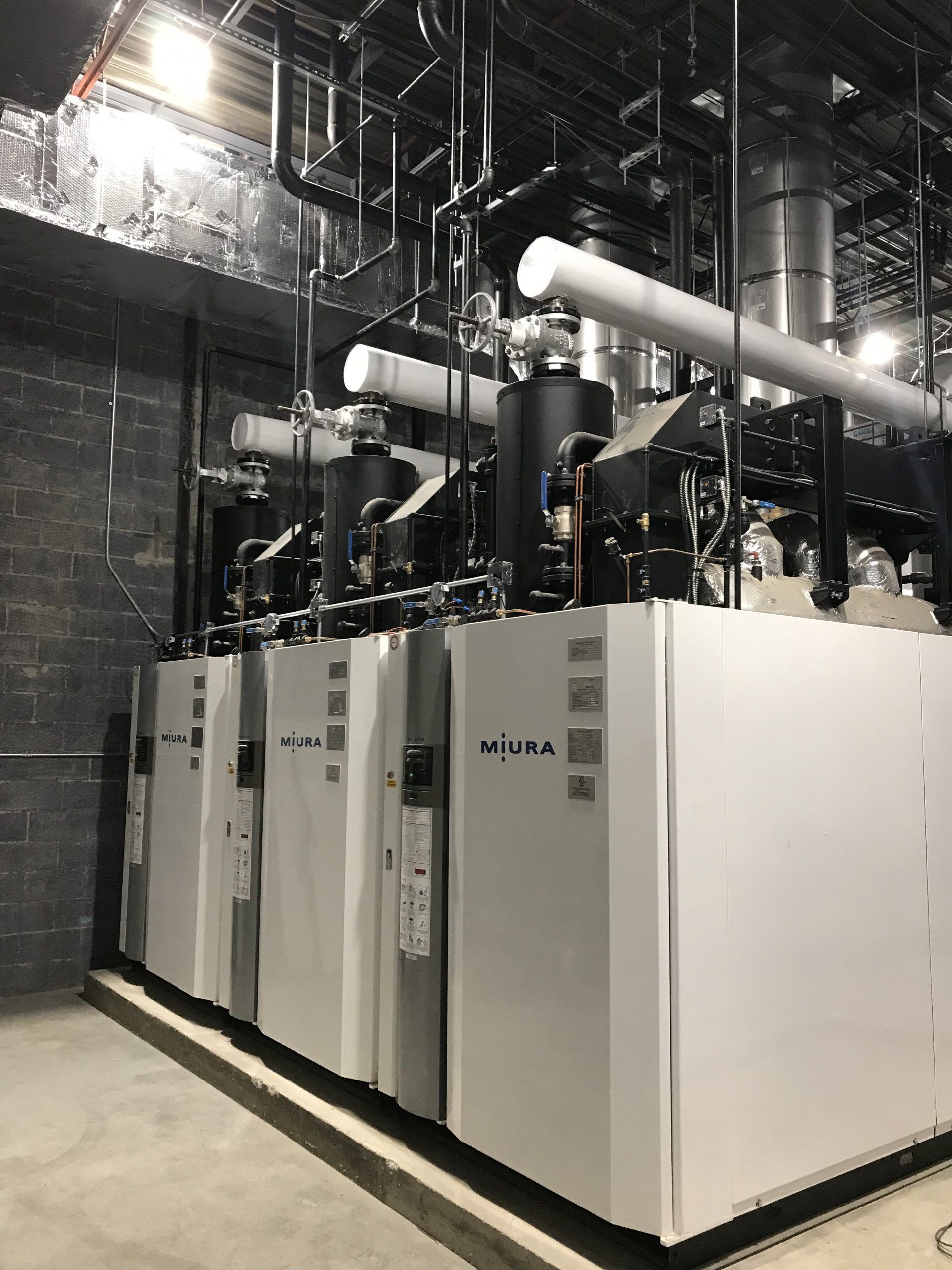 Une pièce avec beaucoup de tuyaux suspendus au plafond.