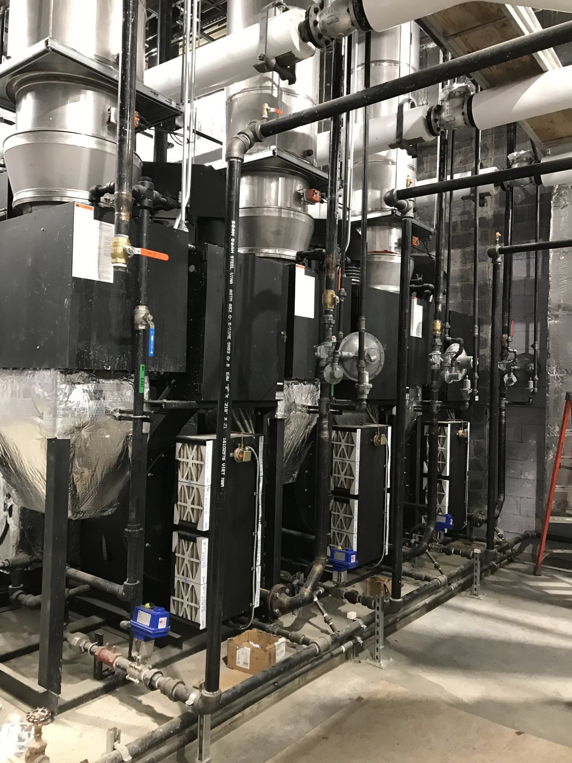 Une pièce remplie de nombreux tuyaux et machines.