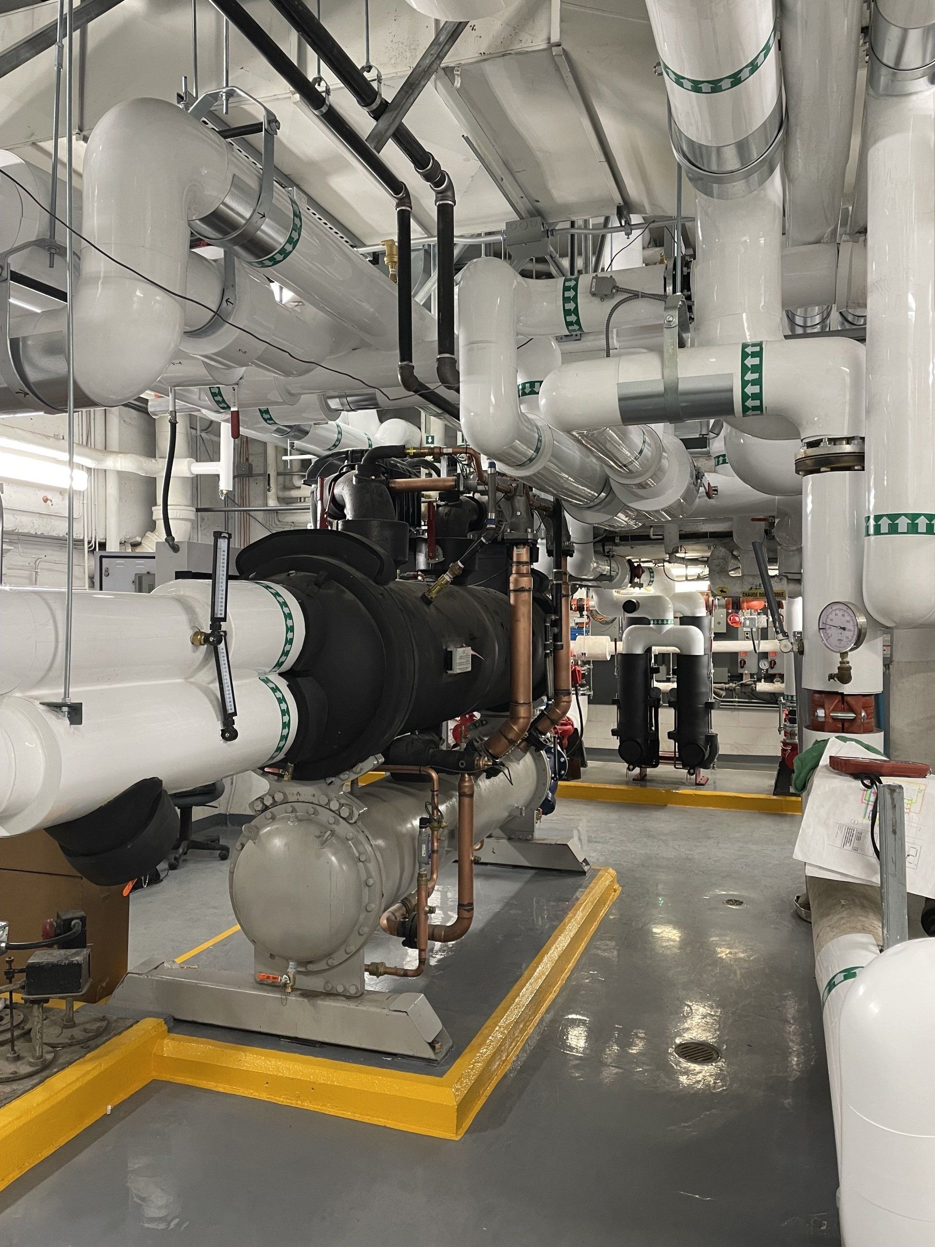 Une pièce remplie de nombreux tuyaux et d'un panneau indiquant « sortie de secours »