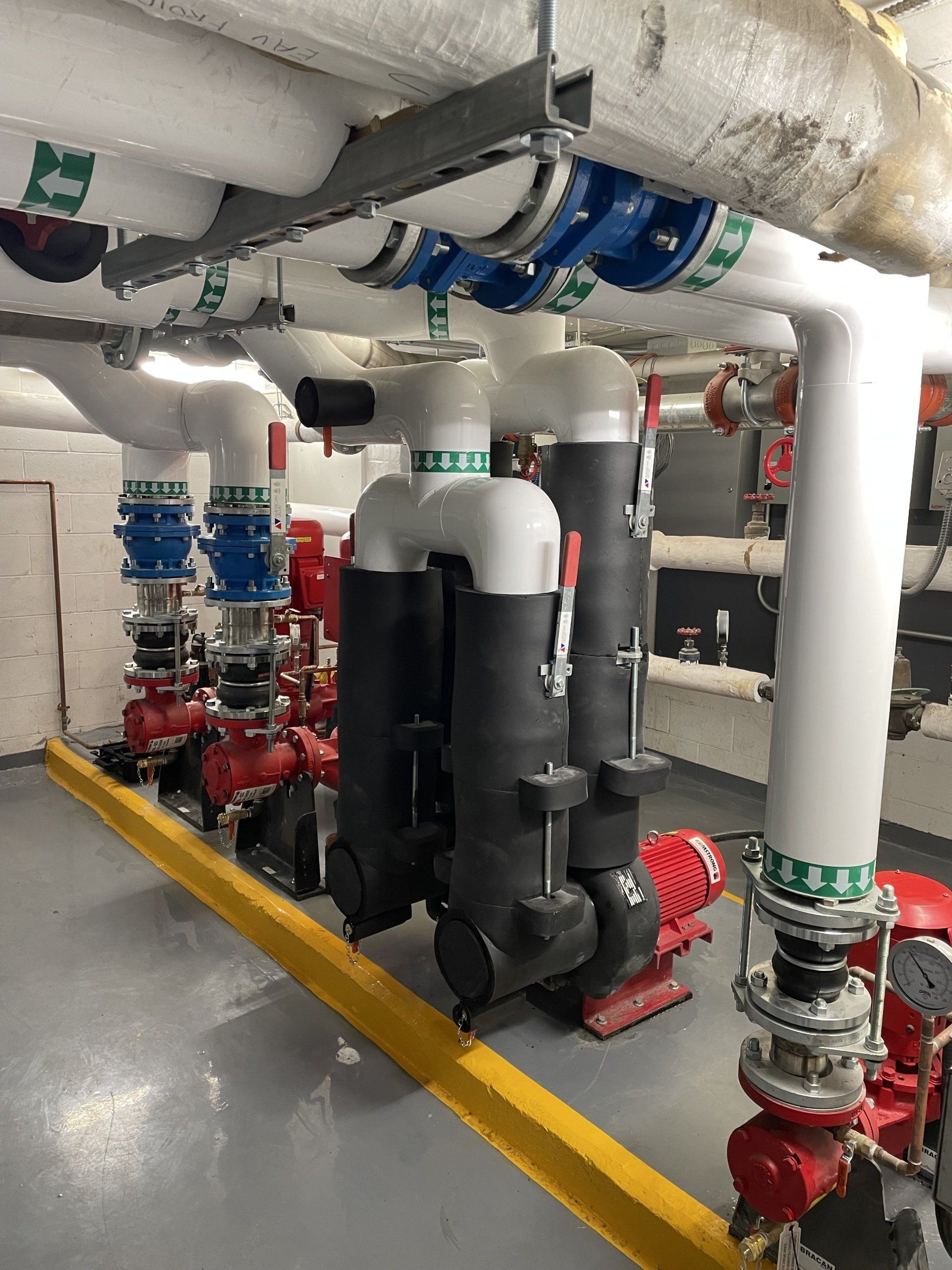 Une pièce remplie de nombreux tuyaux et pompes.