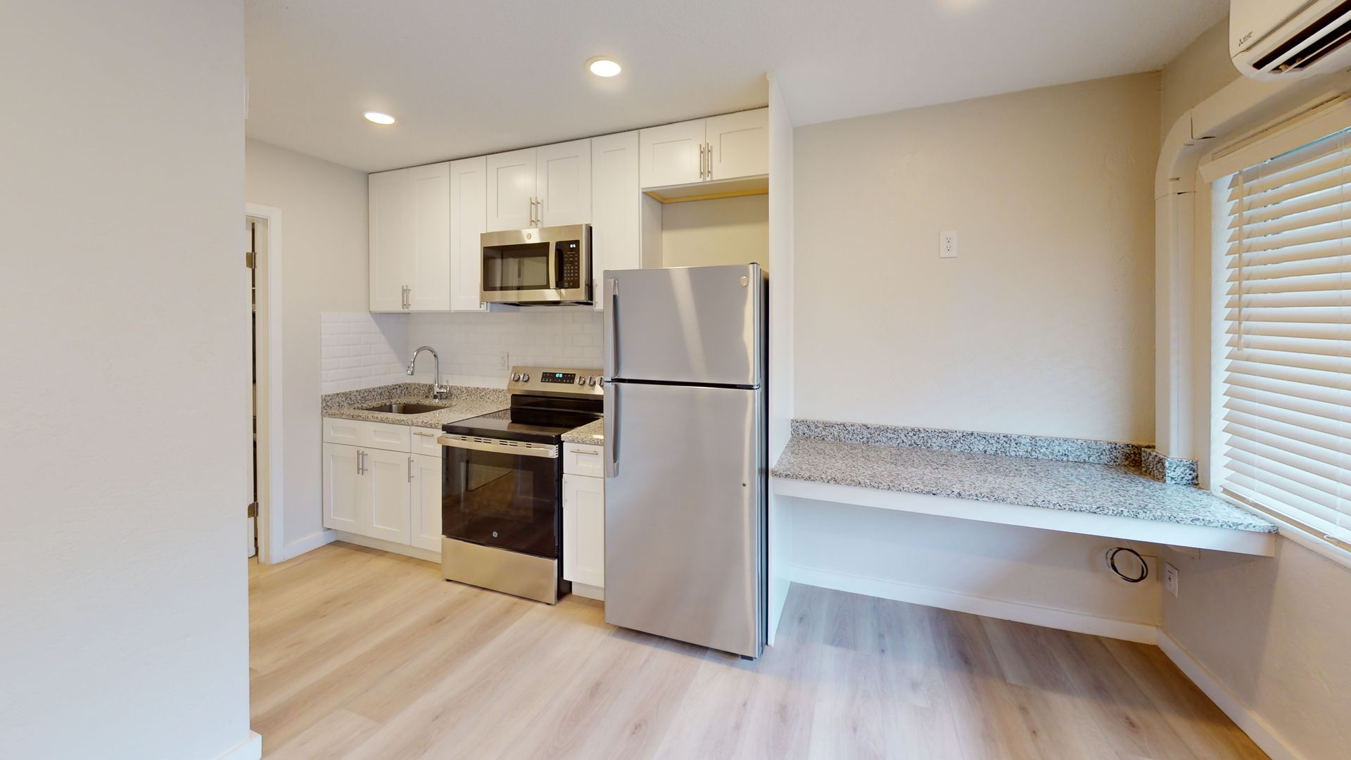 A kitchen with a refrigerator , stove , microwave and sink.