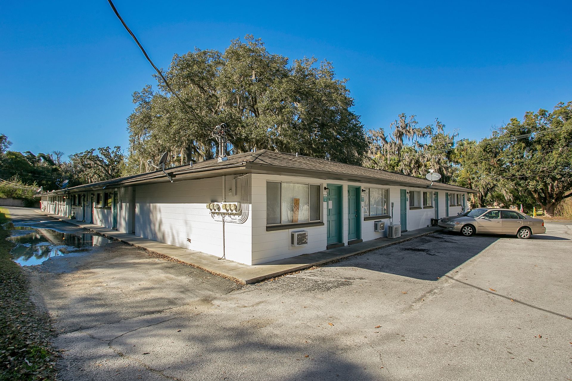 A white house with a car parked in front of it.