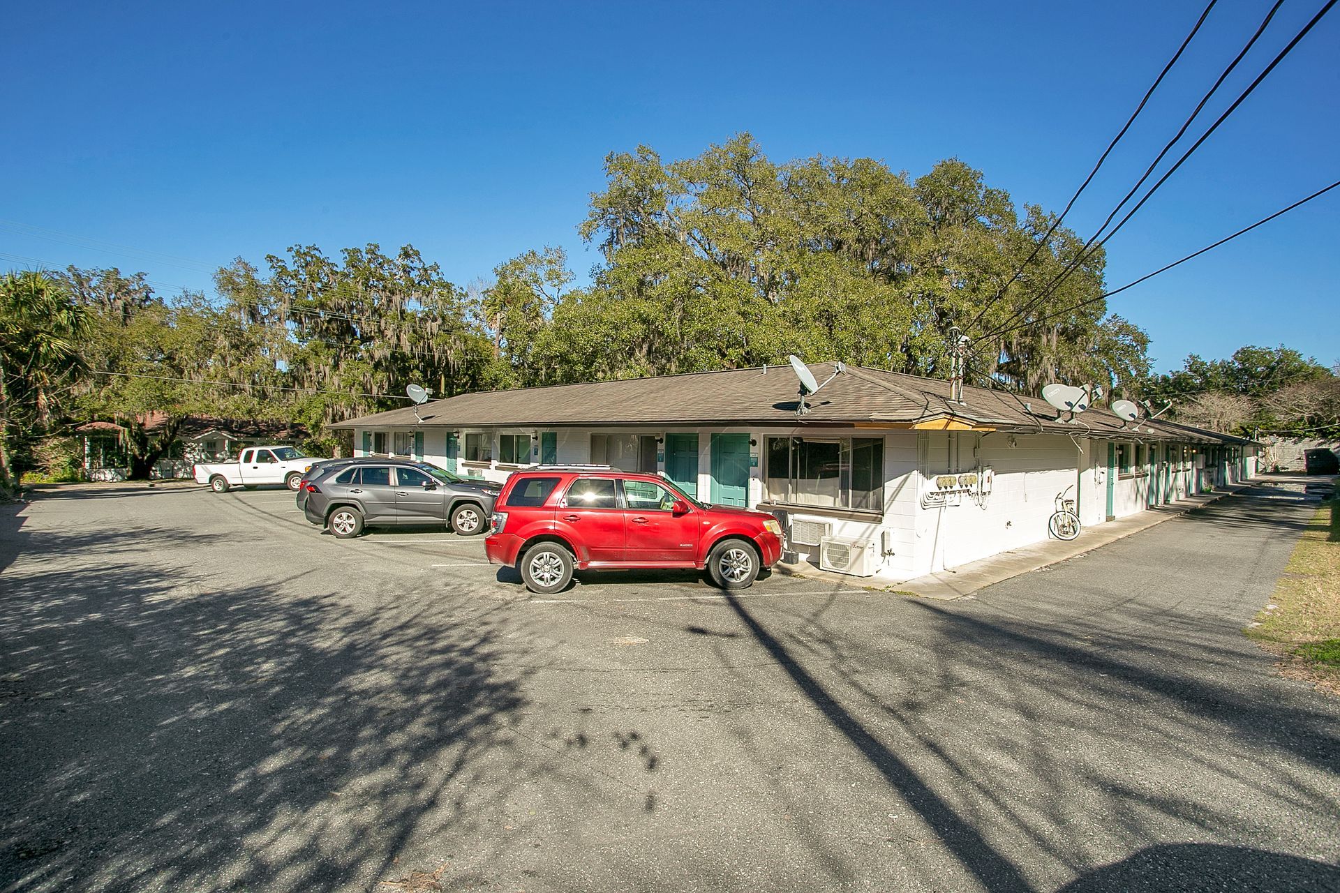 A red car is parked in front of a building.