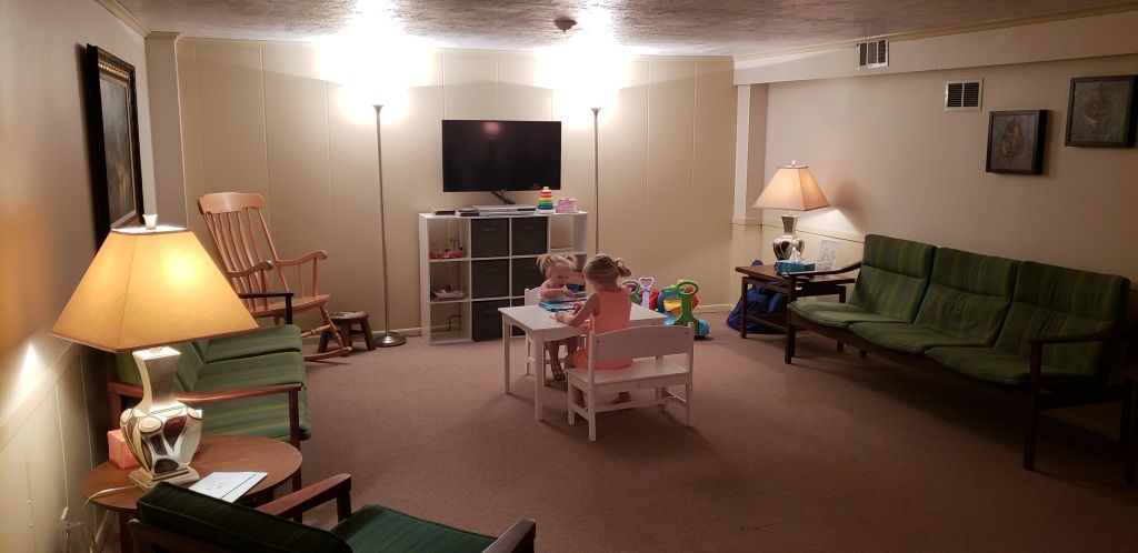 a little girl sits at a table in a waiting room