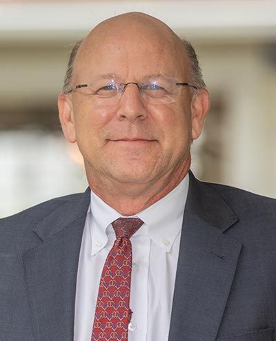 A man in a suit and tie is smiling for the camera.