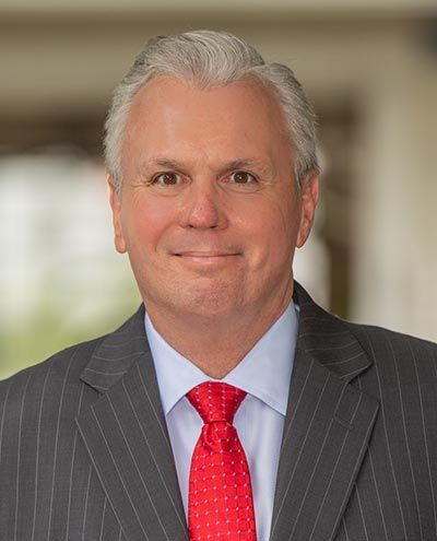 A man in a suit and tie is smiling for the camera.