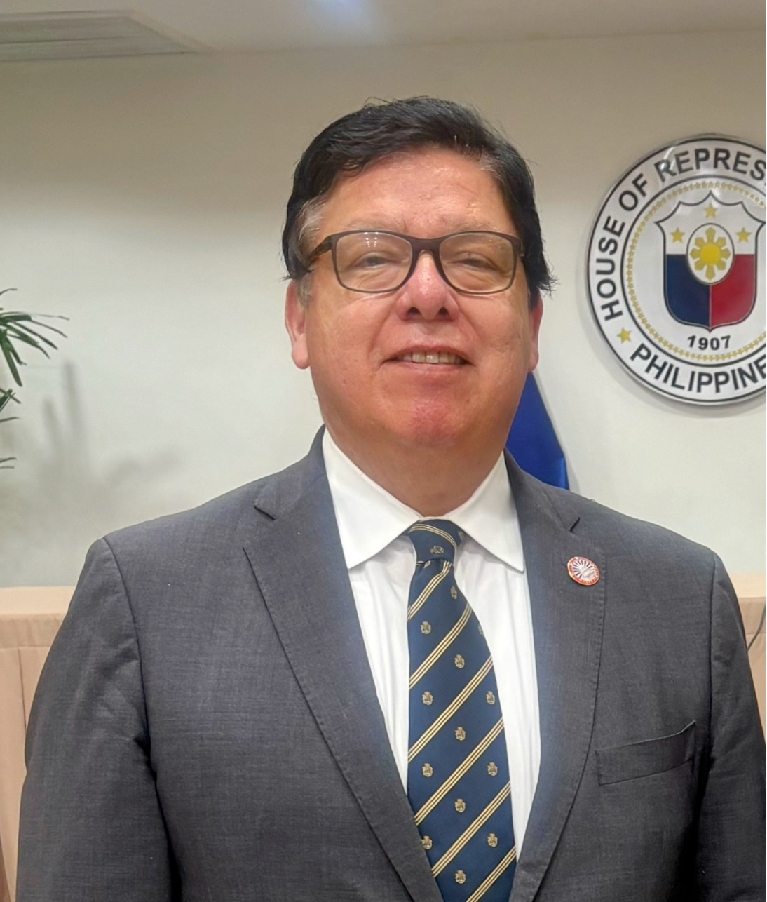 A man in a suit and tie is smiling for the camera.