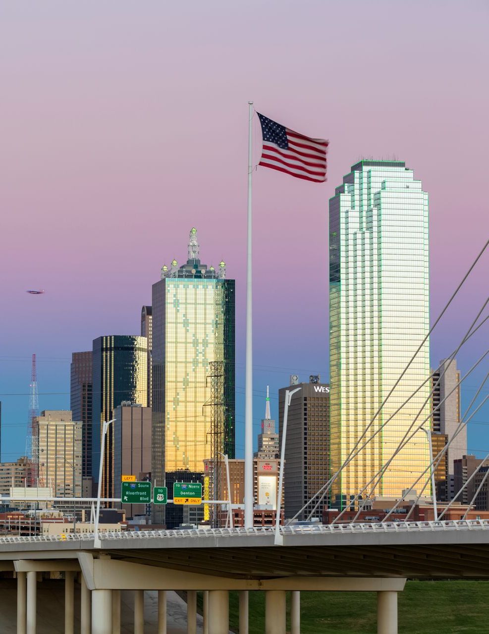 An american flag is flying in front of a city skyline