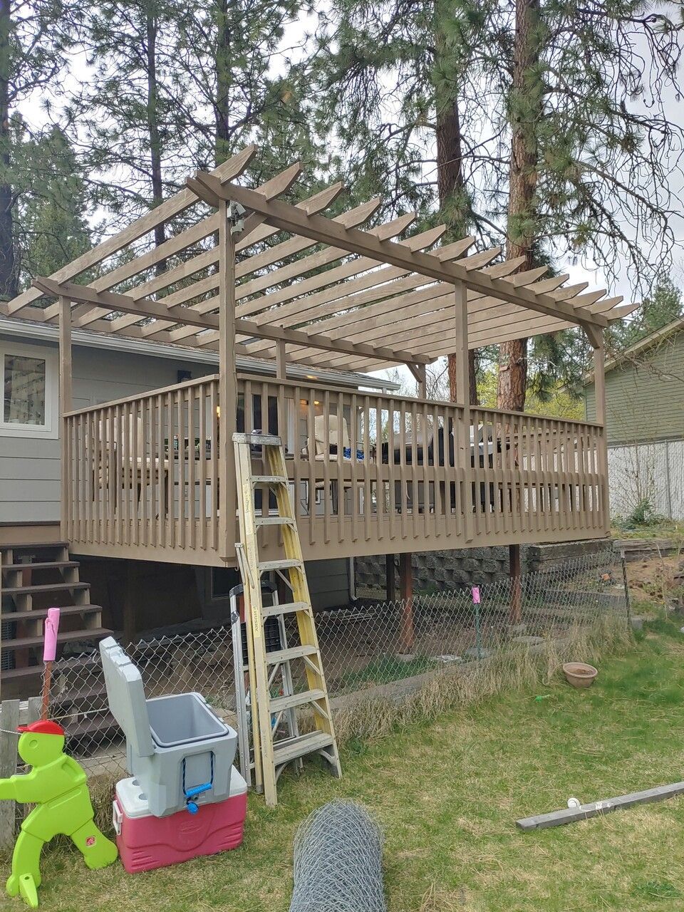 A wooden deck is being built in the backyard of a house.