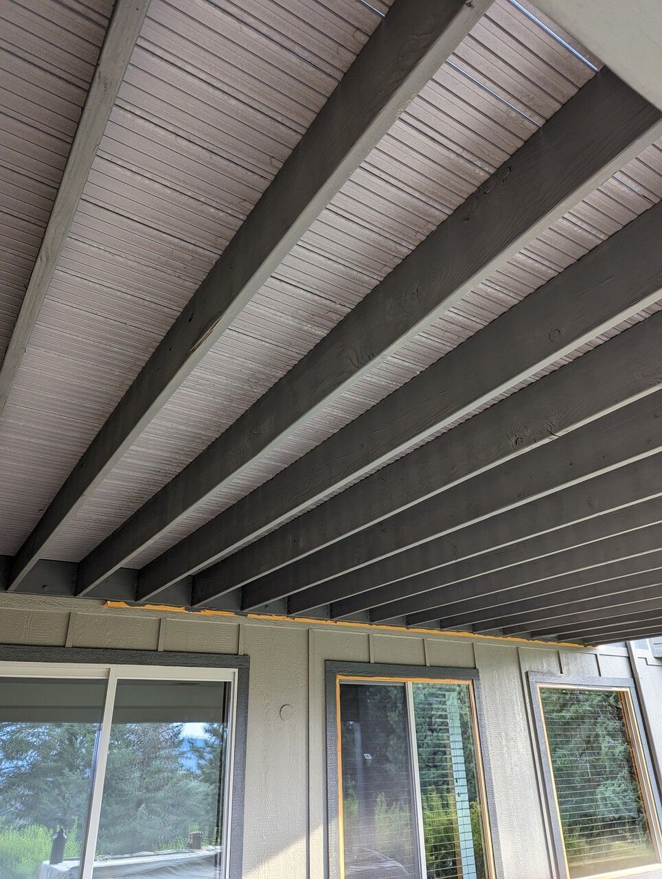 The ceiling of a room with a lot of windows and beams.