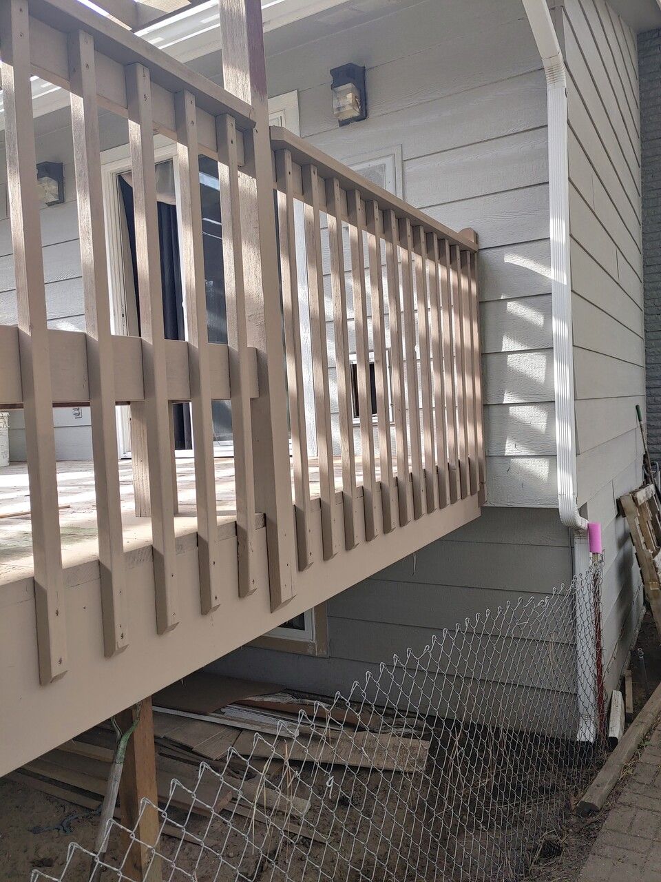 A wooden deck with a railing is attached to a house