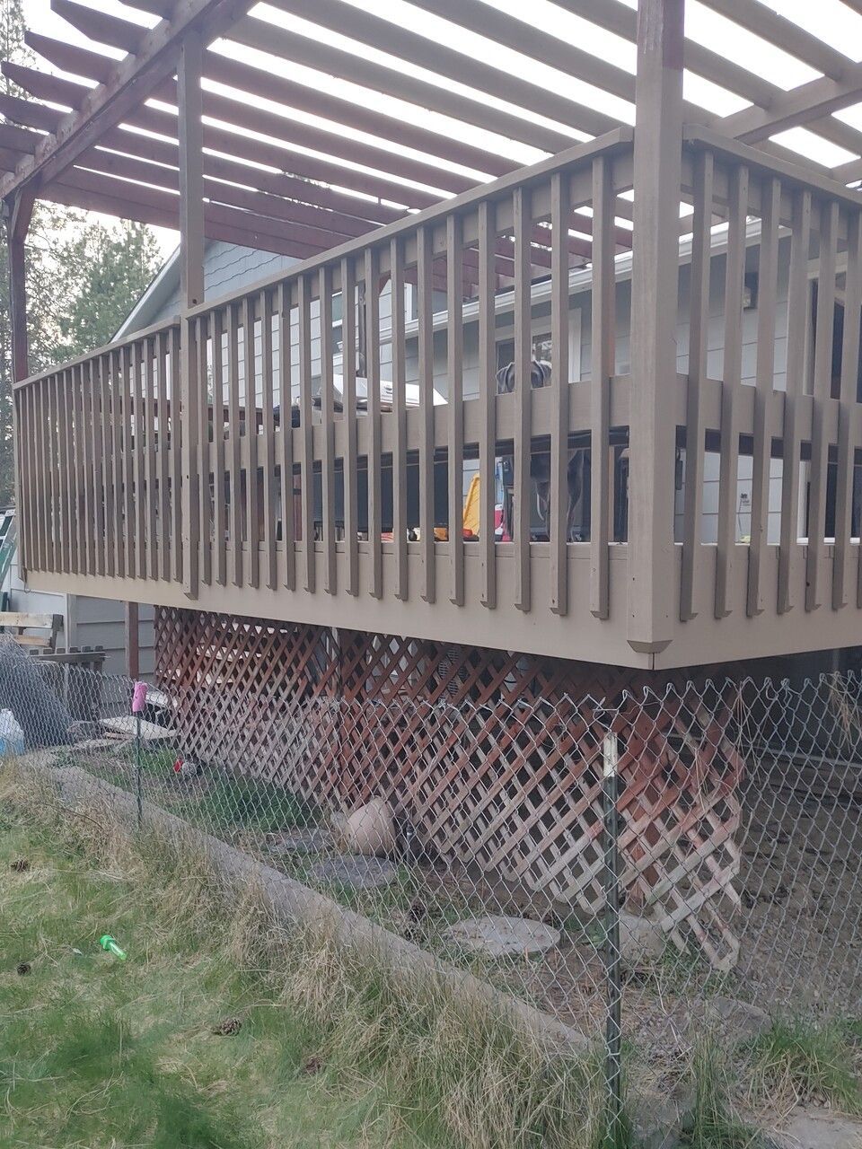A wooden deck with a pergola on top of it