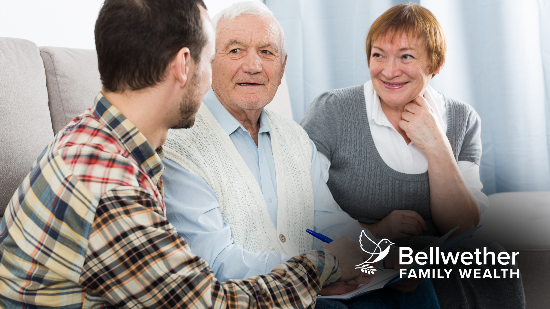 An elderly couple is sitting at a table talking to a man.