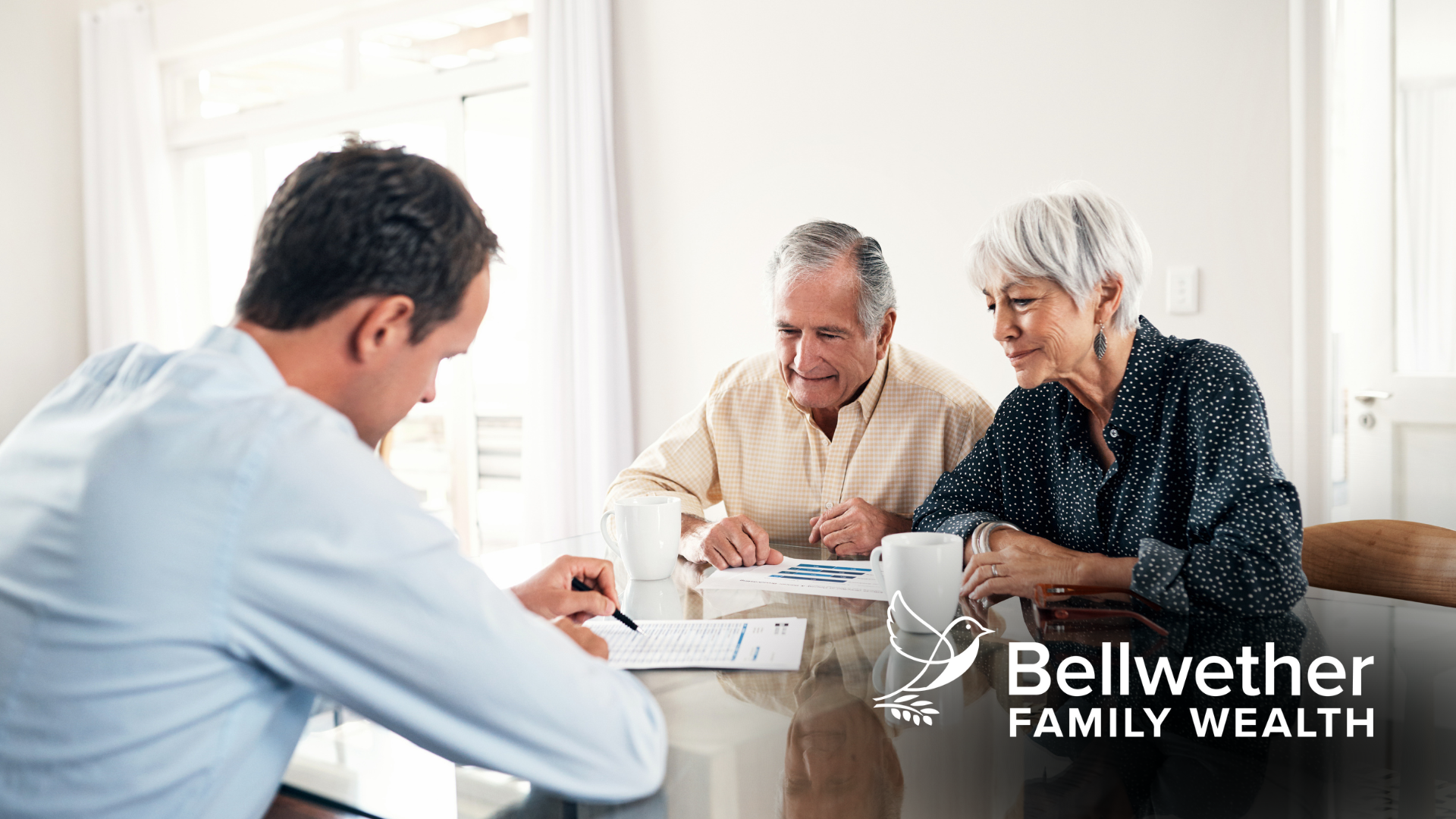 A man is sitting at a table talking to an elderly couple.