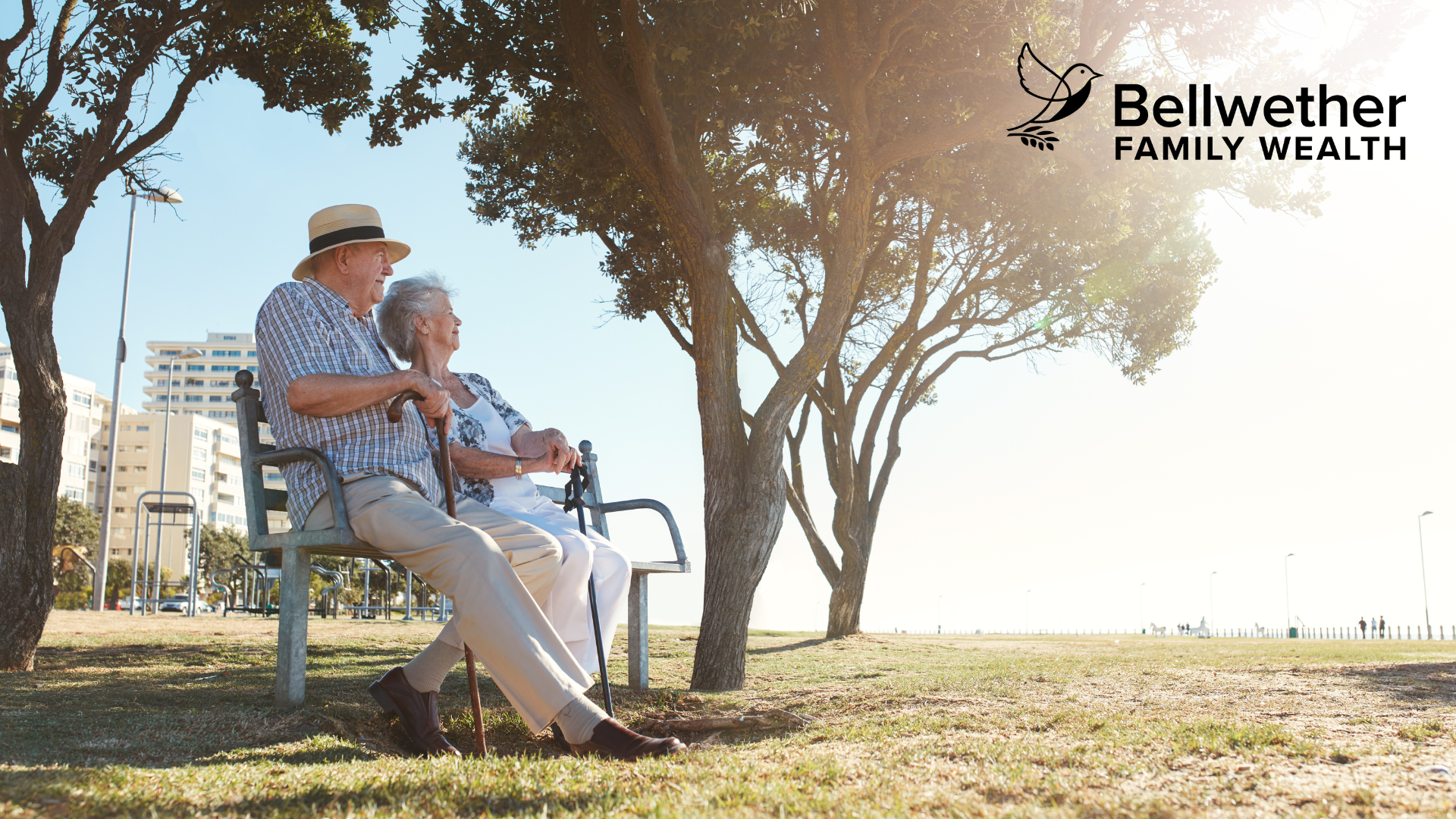 A man and woman are sitting on a bench in a park.