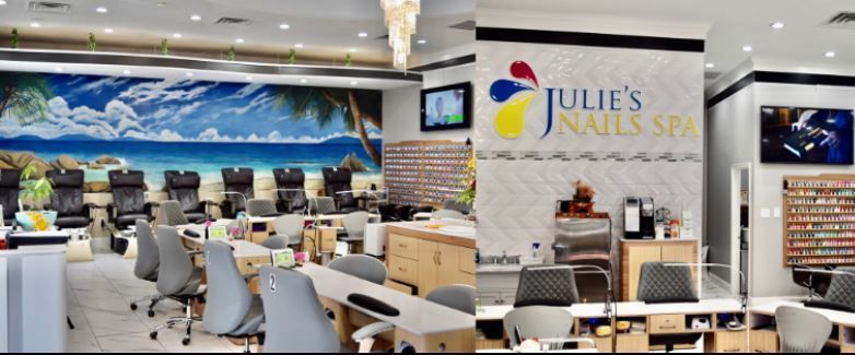 Interior of a nail salon with manicure tables, pedicure chairs, and a beach mural. 