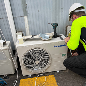 Man Repairing A Panasonic Split System — Rapidcool Air Conditioning & Electrical in Illawarra, NSW