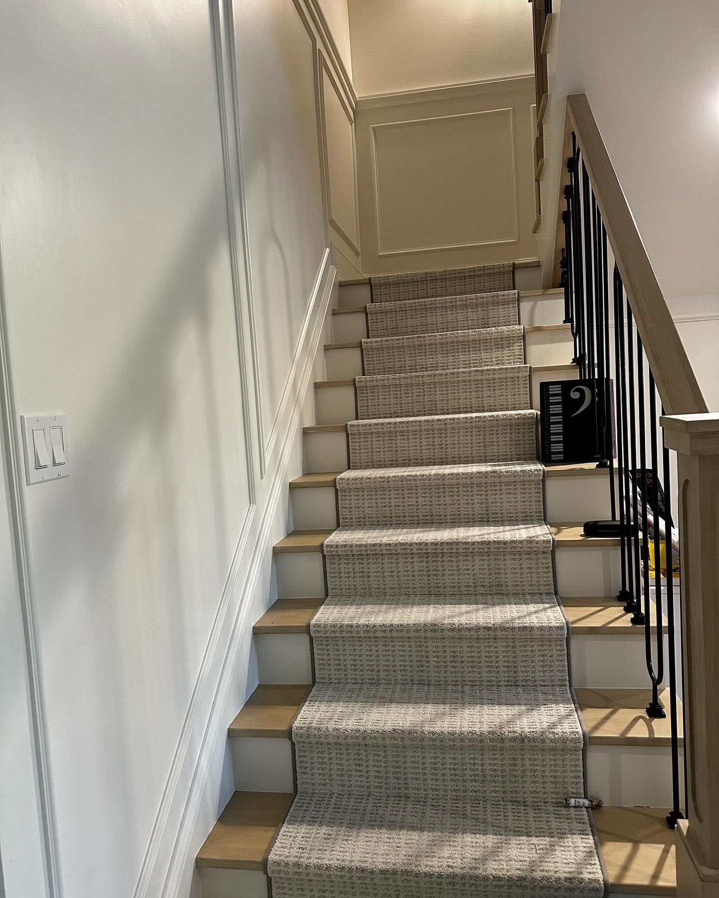 A staircase with a carpeted staircase leading up to the second floor.