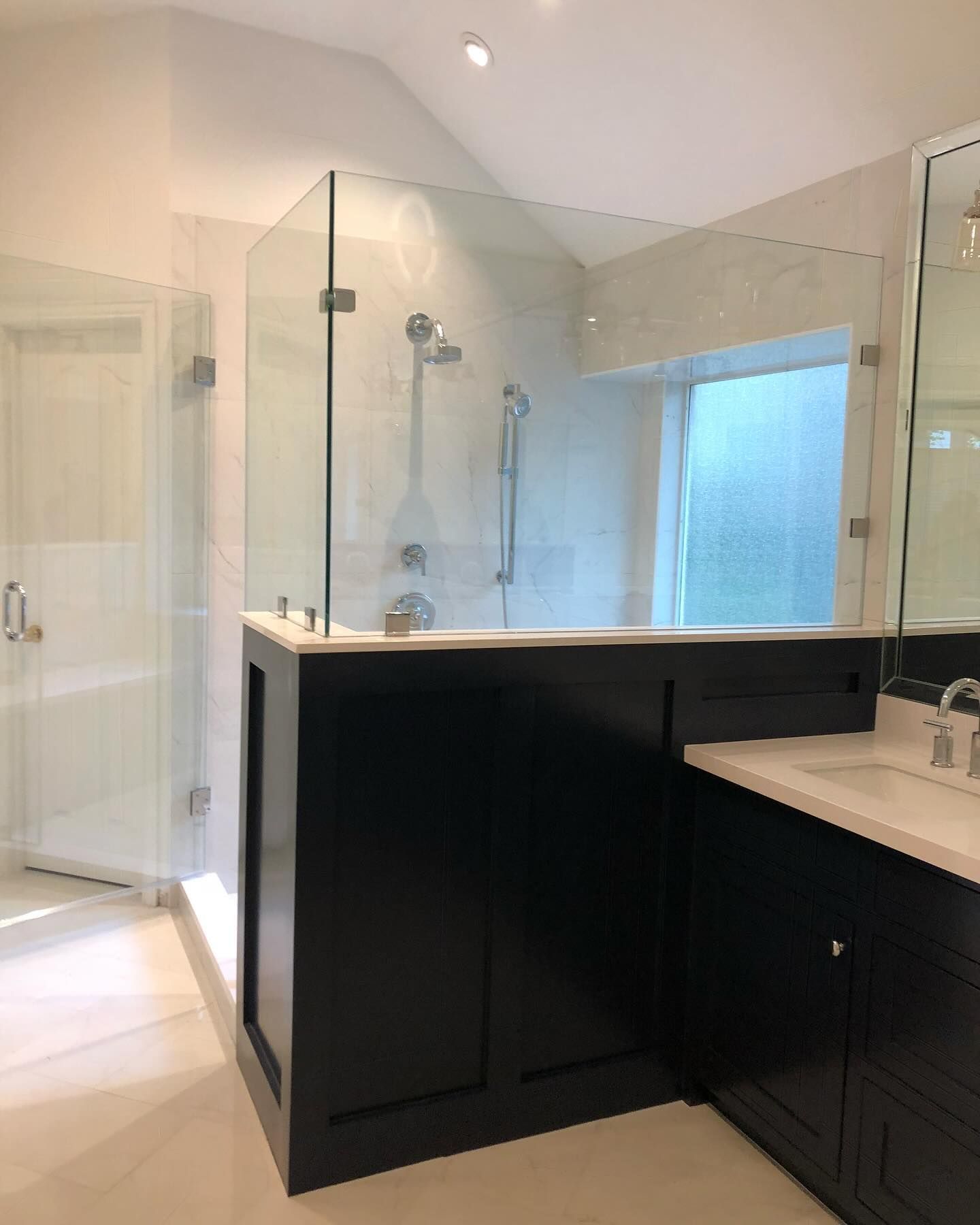 A bathroom with a walk in shower and a sink