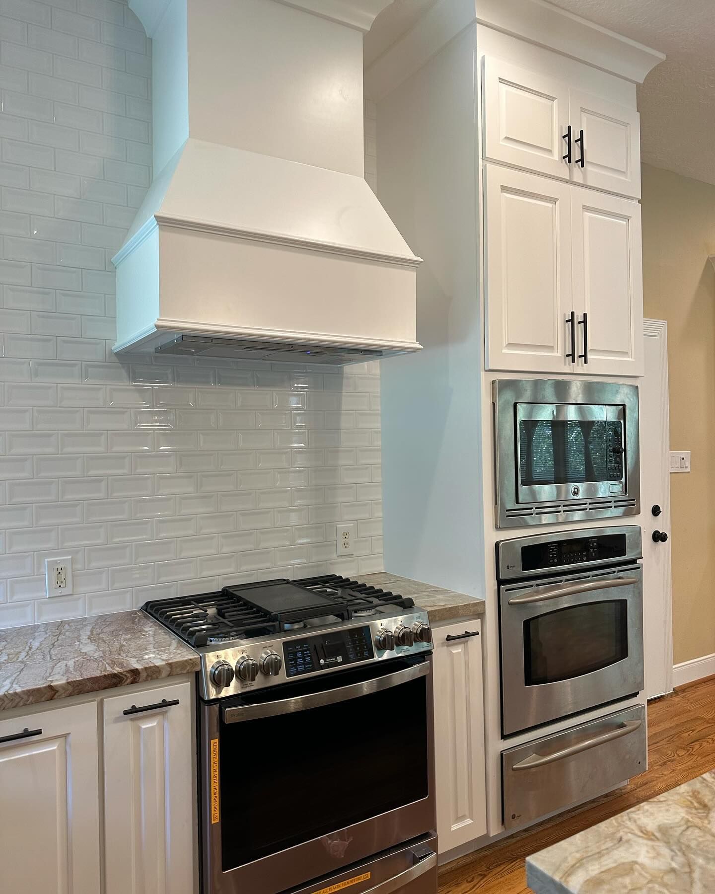 A kitchen with stainless steel appliances and white cabinets.