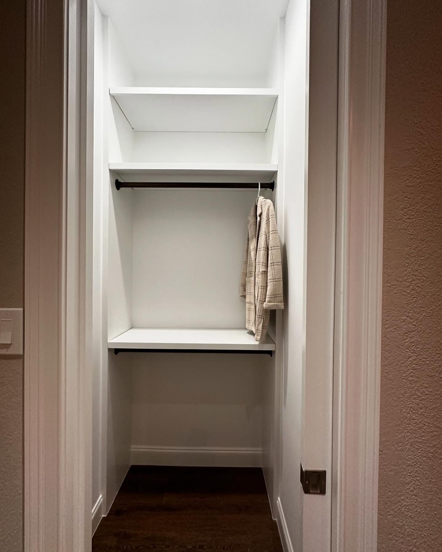 A small closet with shelves and a hanger.