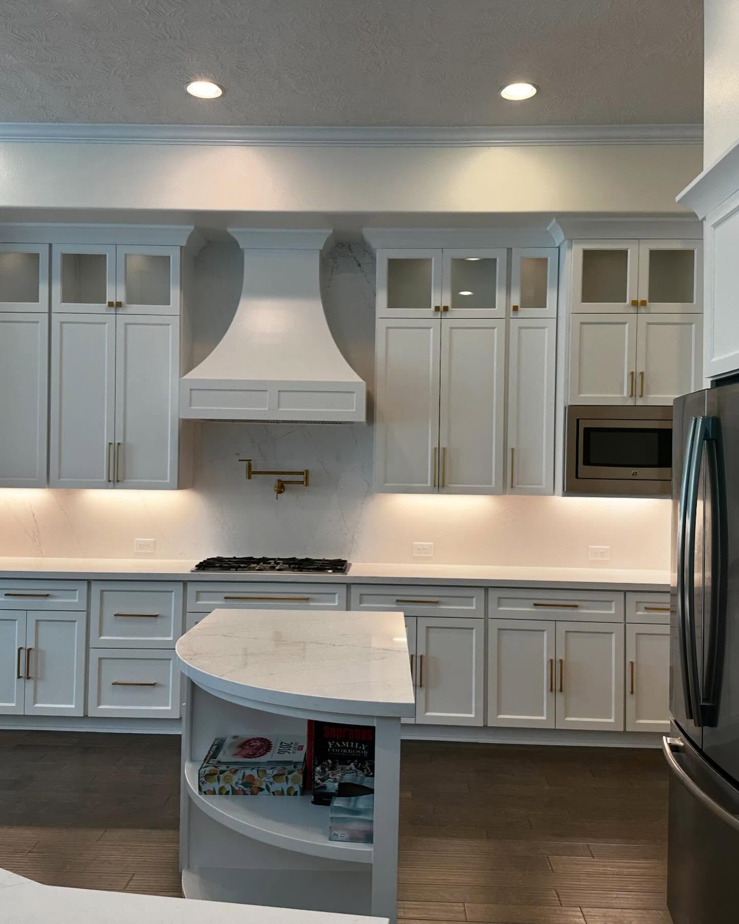 A kitchen with white cabinets and a black refrigerator
