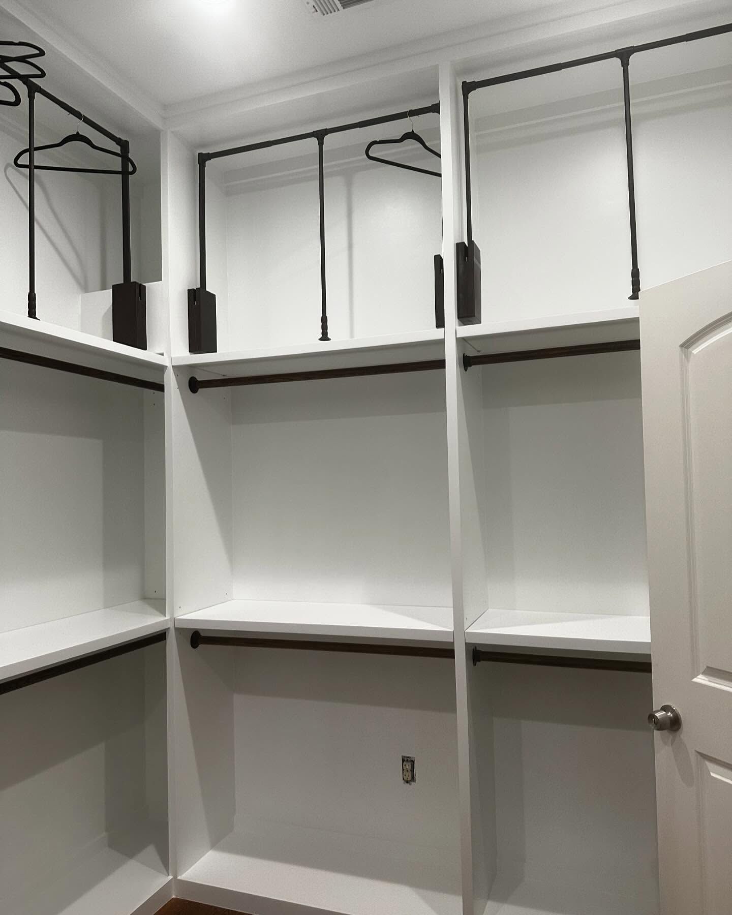 A walk in closet with lots of shelves and hangers