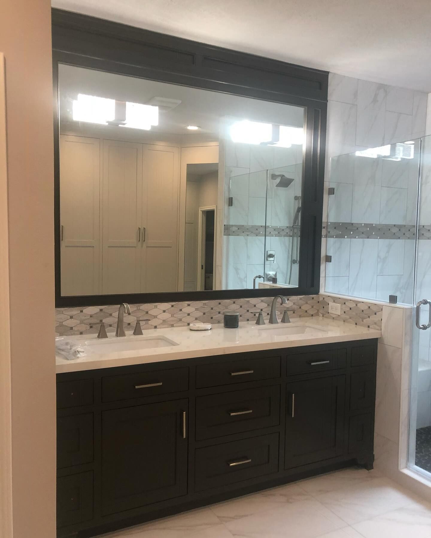 A bathroom with two sinks and a large mirror