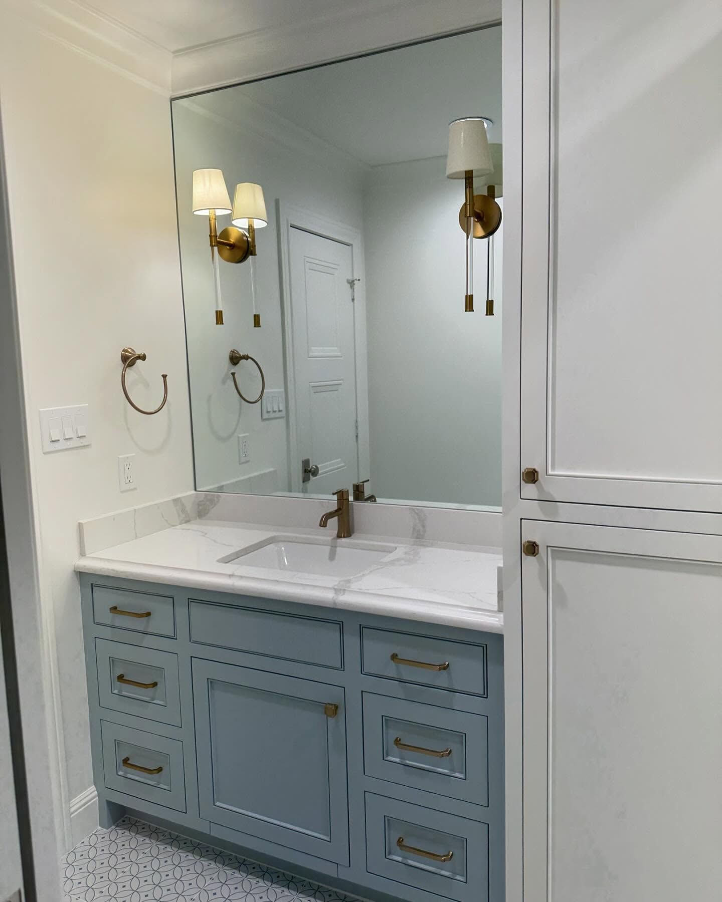 A bathroom with a sink and a large mirror.