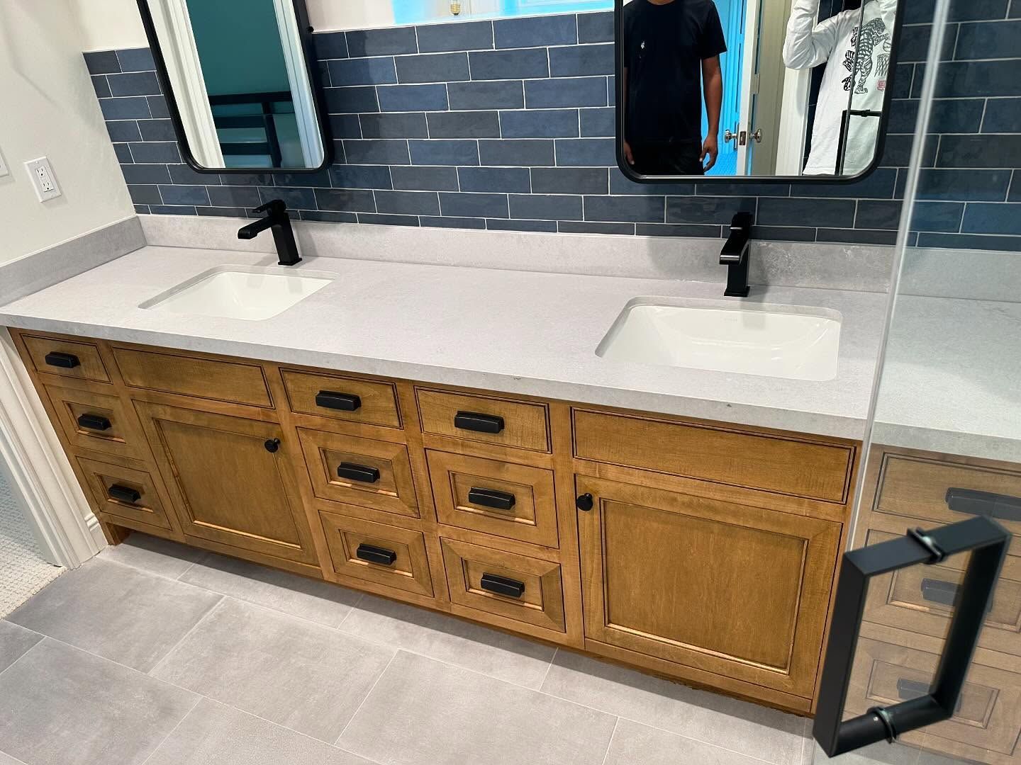 A bathroom with two sinks and a mirror.