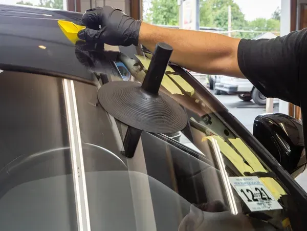 A man is working on a car windshield A man is working on a car windshield