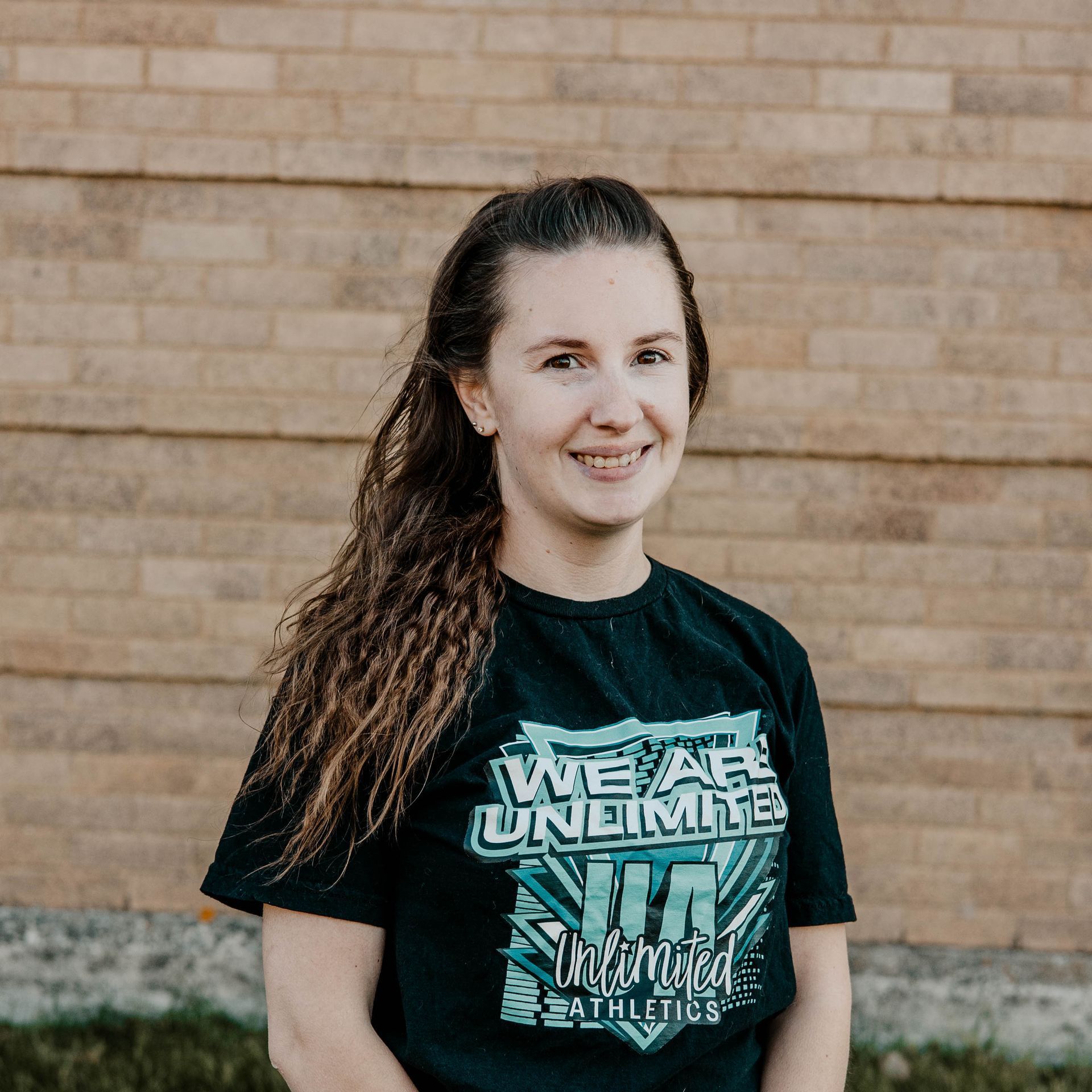 A woman is sitting on a wooden box with her legs crossed.