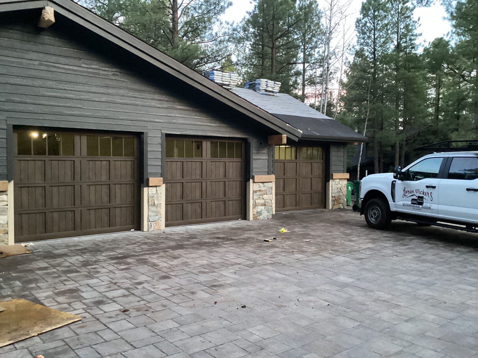 A white truck is parked in front of a garage door.