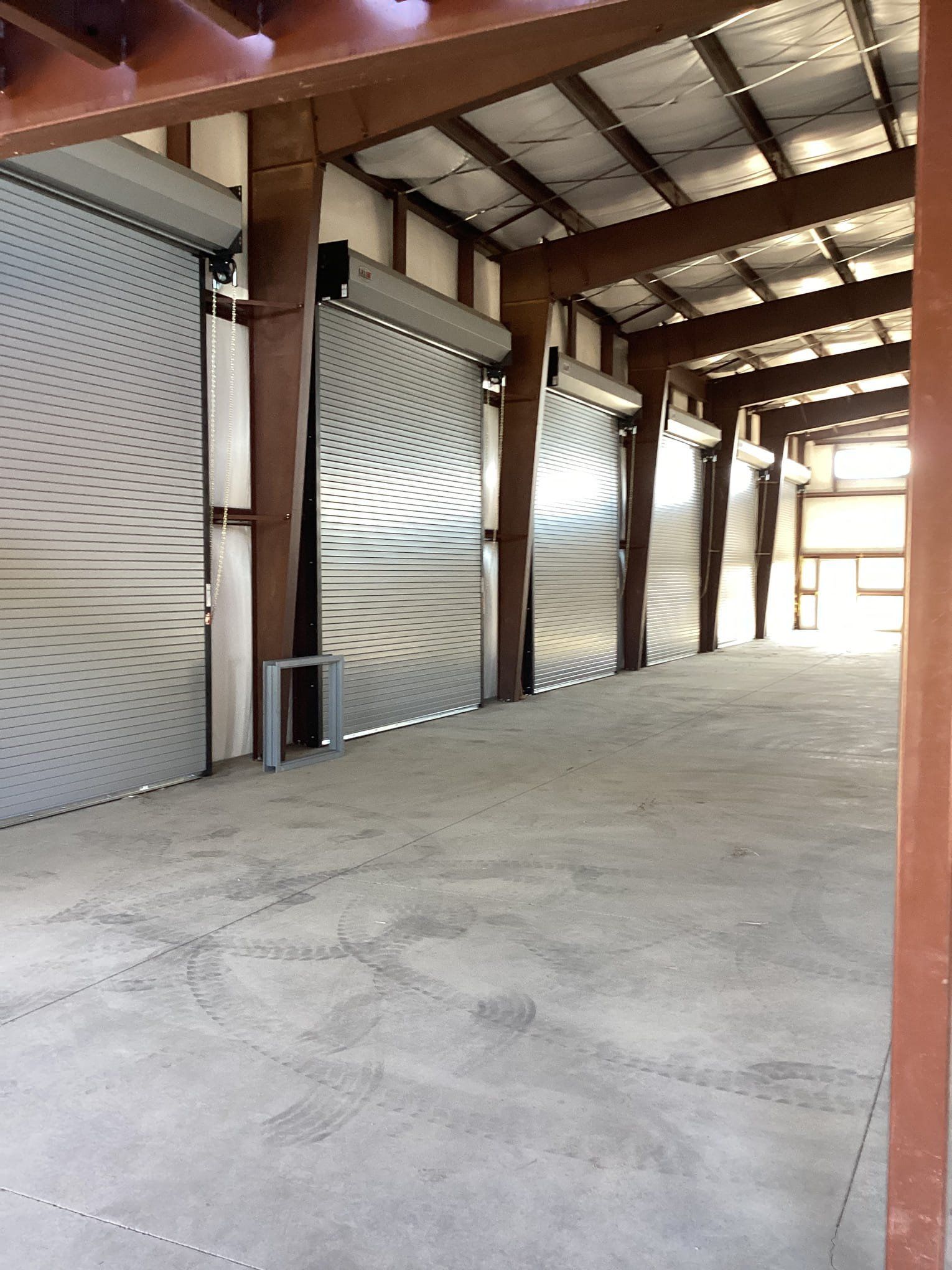 An empty warehouse with a lot of roller doors