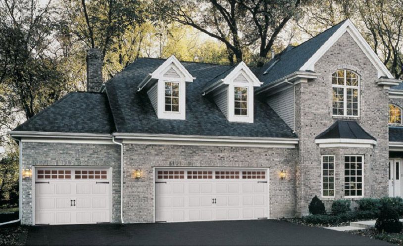 A Large Brick House With Two Wooden Garage Doors - Flagstaff, AZ - Loren Vickers