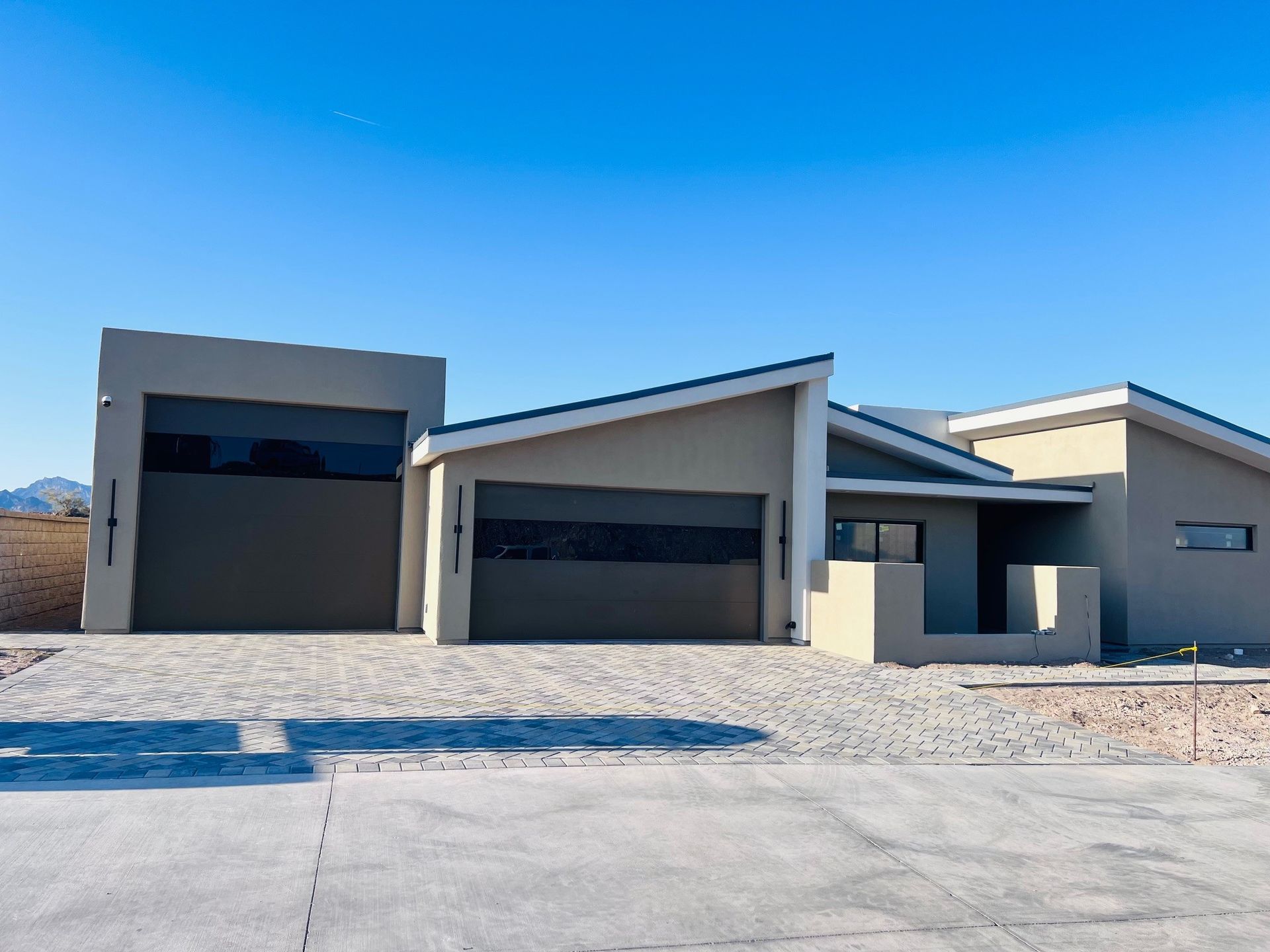 A house with two garage doors and a concrete driveway
