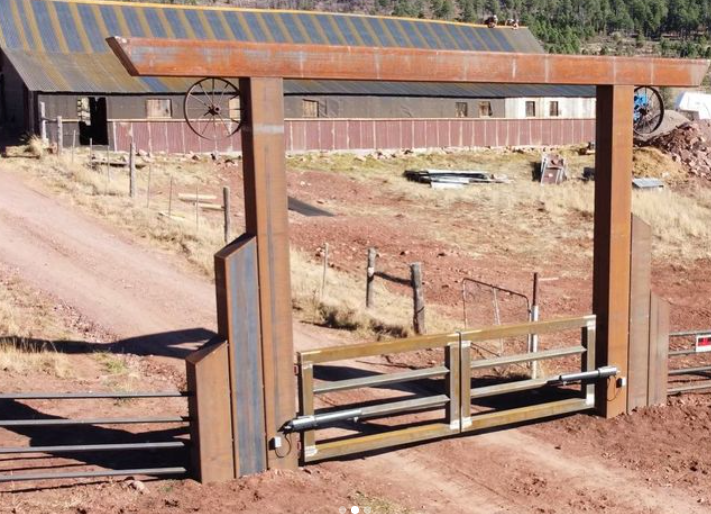 A rusty gate with a wagon wheel on top of it