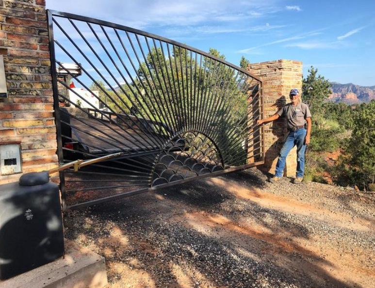 A man is standing in front of a broken gate.